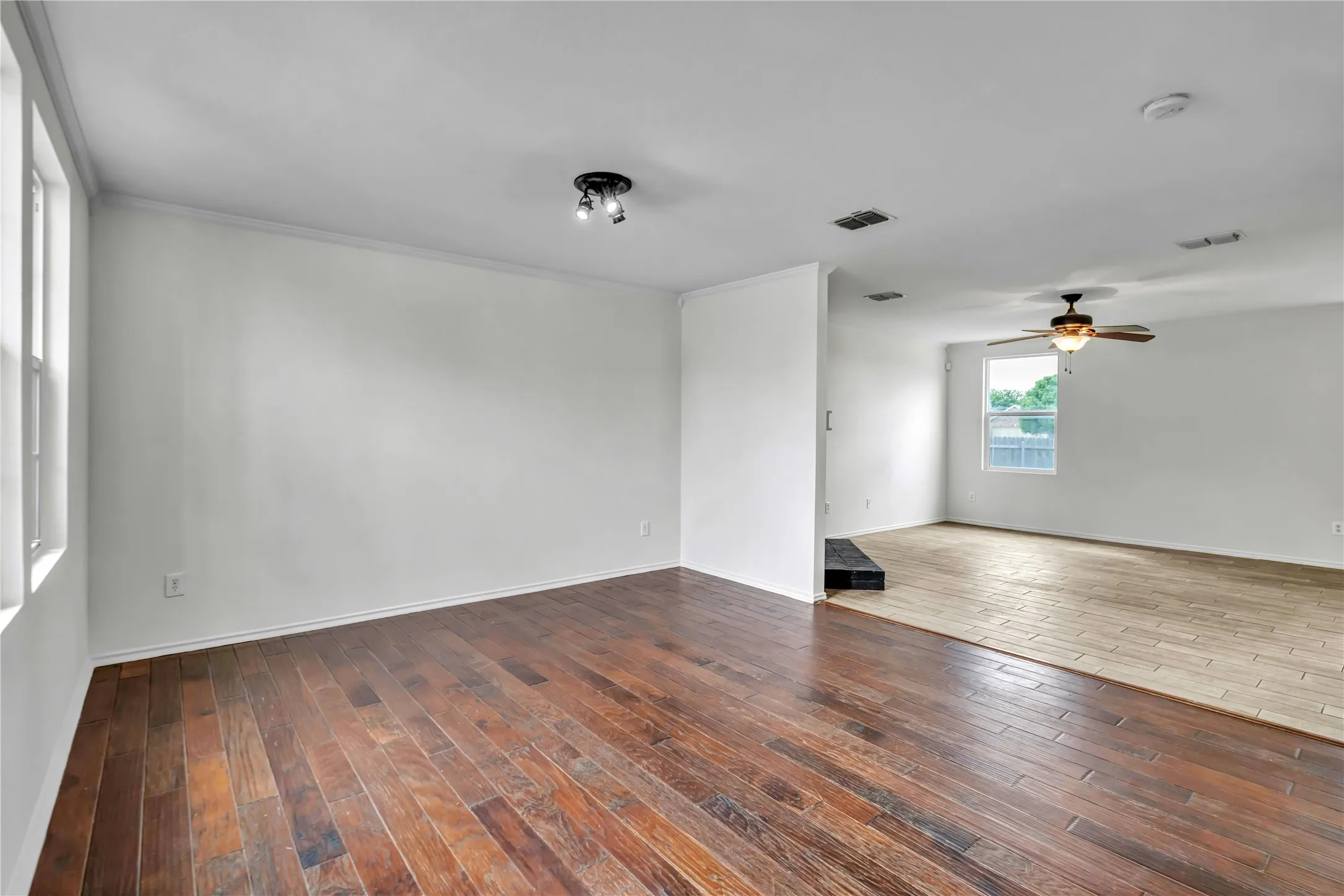 Expansive interior space featuring rich wood-finish flooring and crisp white walls