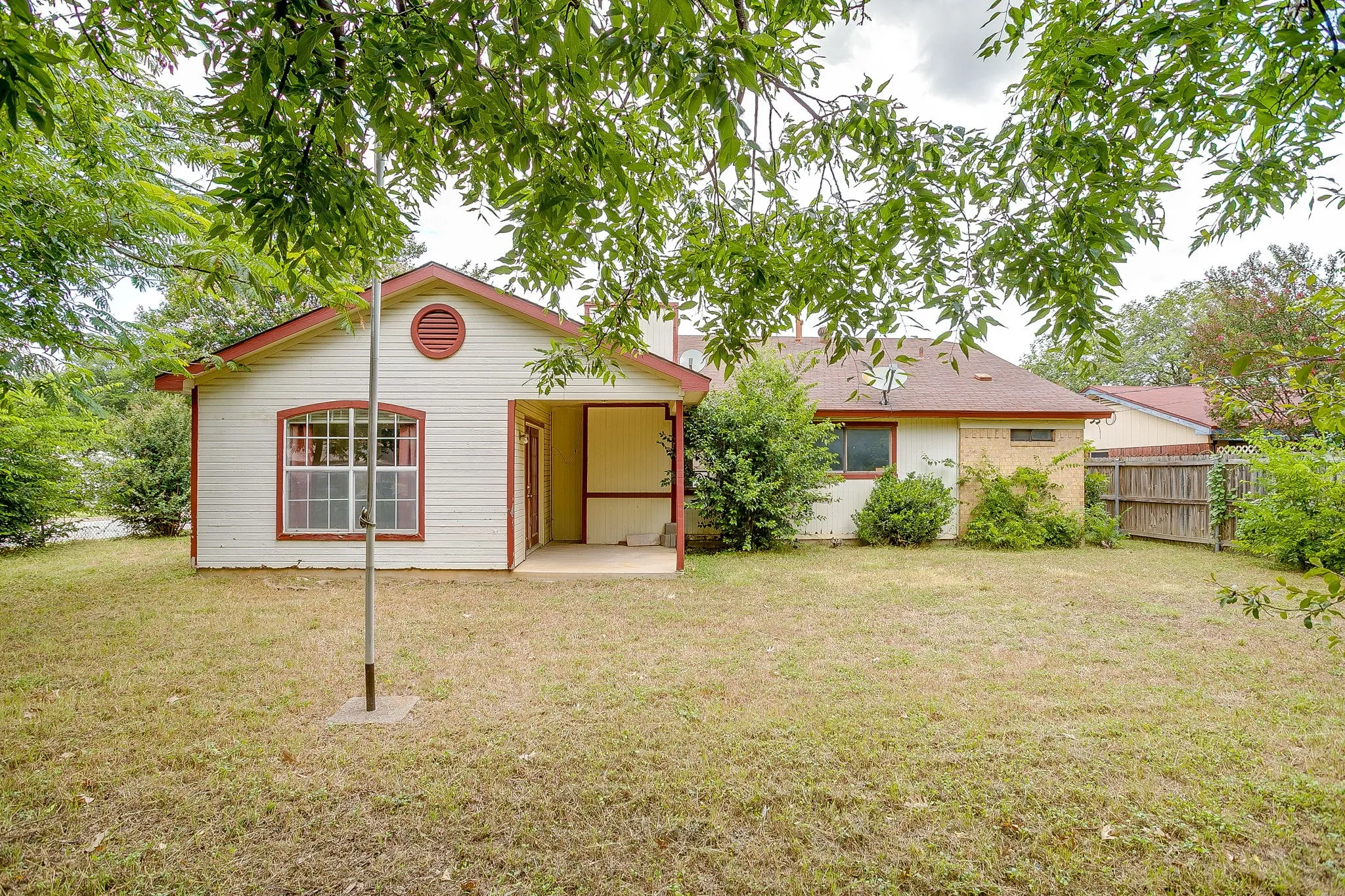 Expansive backyard with a covered patio and fencing