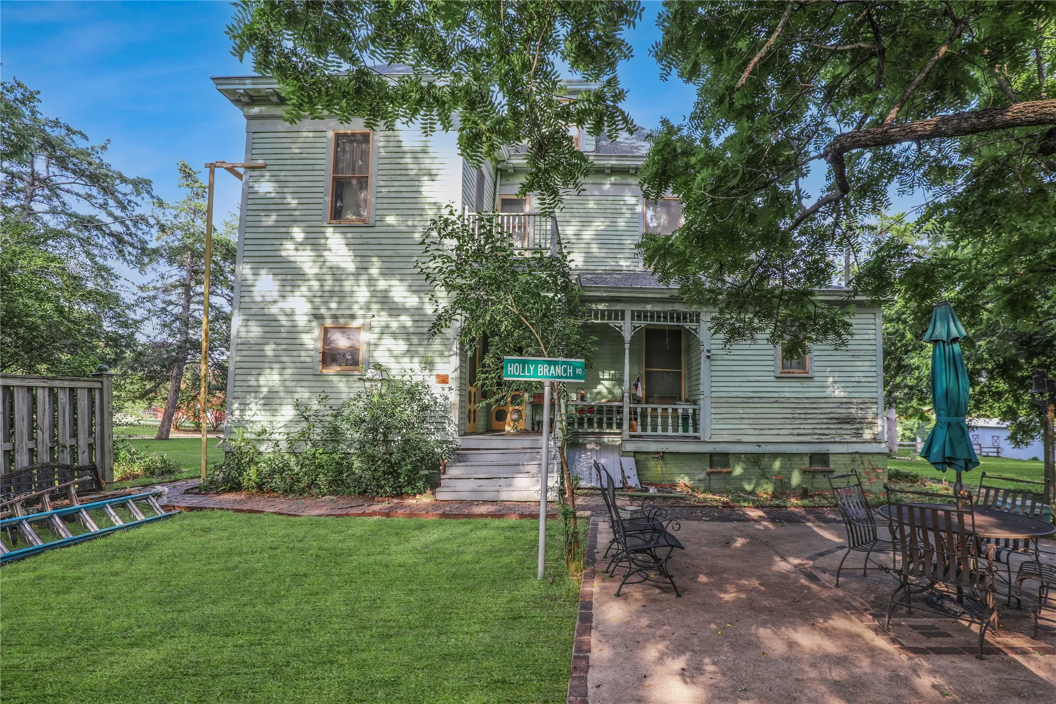 Traditional siding exterior with multiple windows, a covered front porch, and a second-story balcony