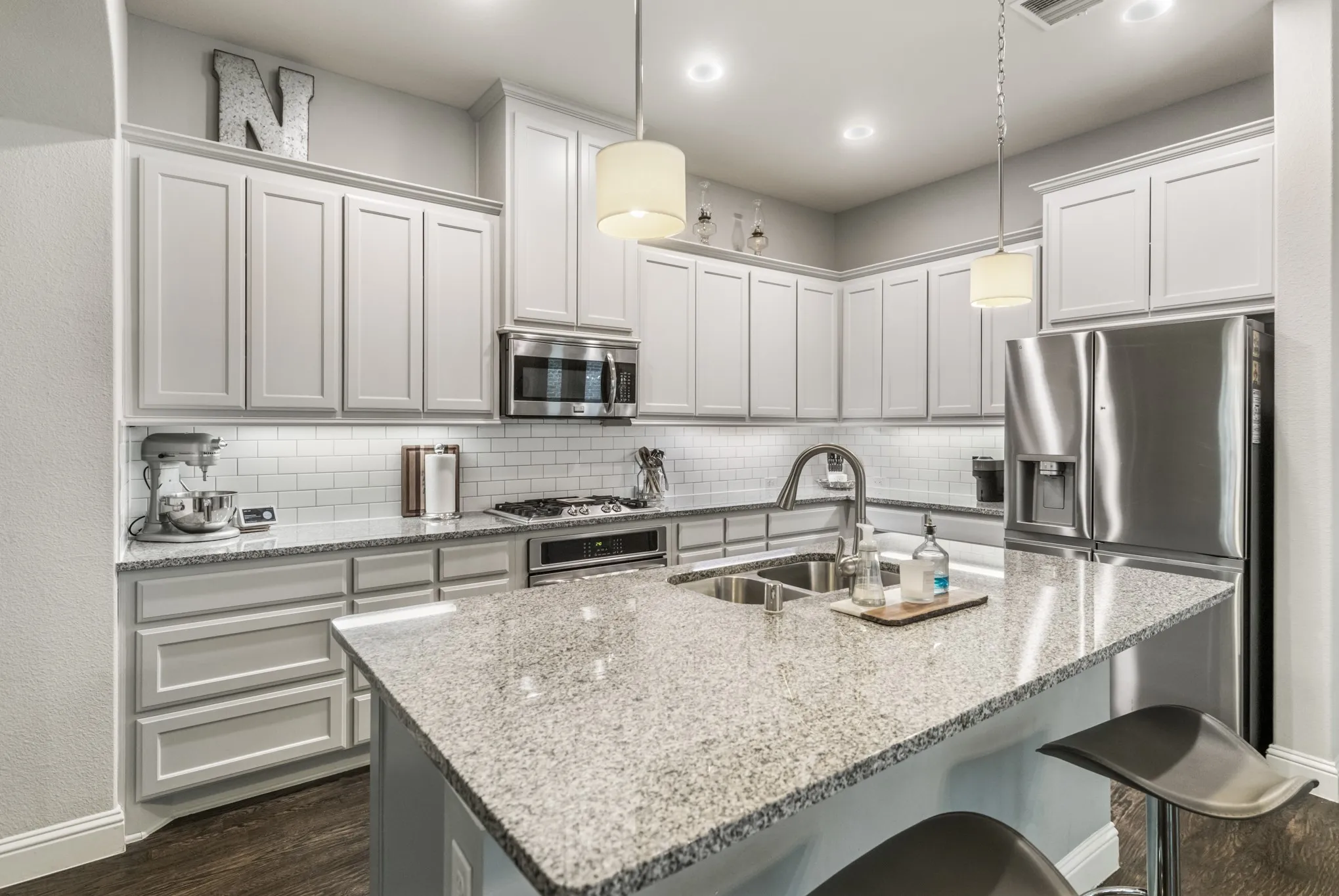 Spacious living area featuring wood-finish flooring, crown molding, recessed lighting, and a ceiling fan
