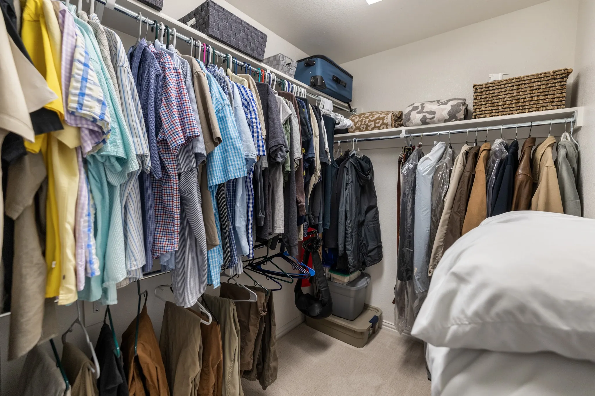 Spacious walk-in closet featuring wire shelving and multiple hanging rods for ample storage