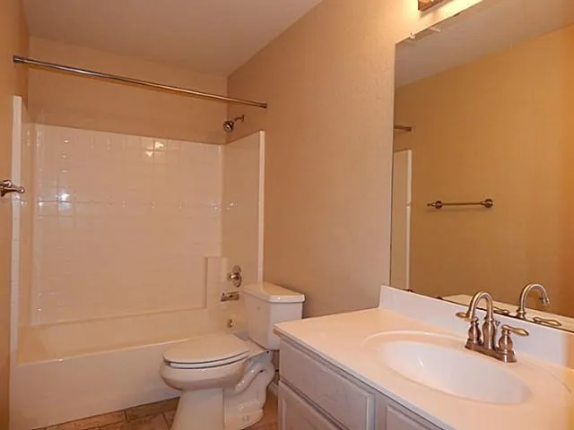 Bathroom with a white vanity featuring an integrated sink, brushed nickel faucet, and a large wall-mounted mirror