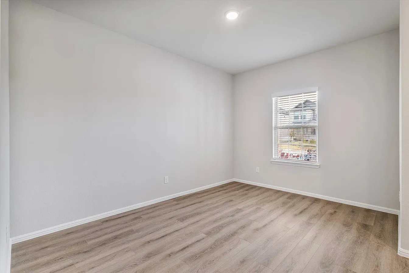 Interior room featuring light-toned walls and wood-finish flooring