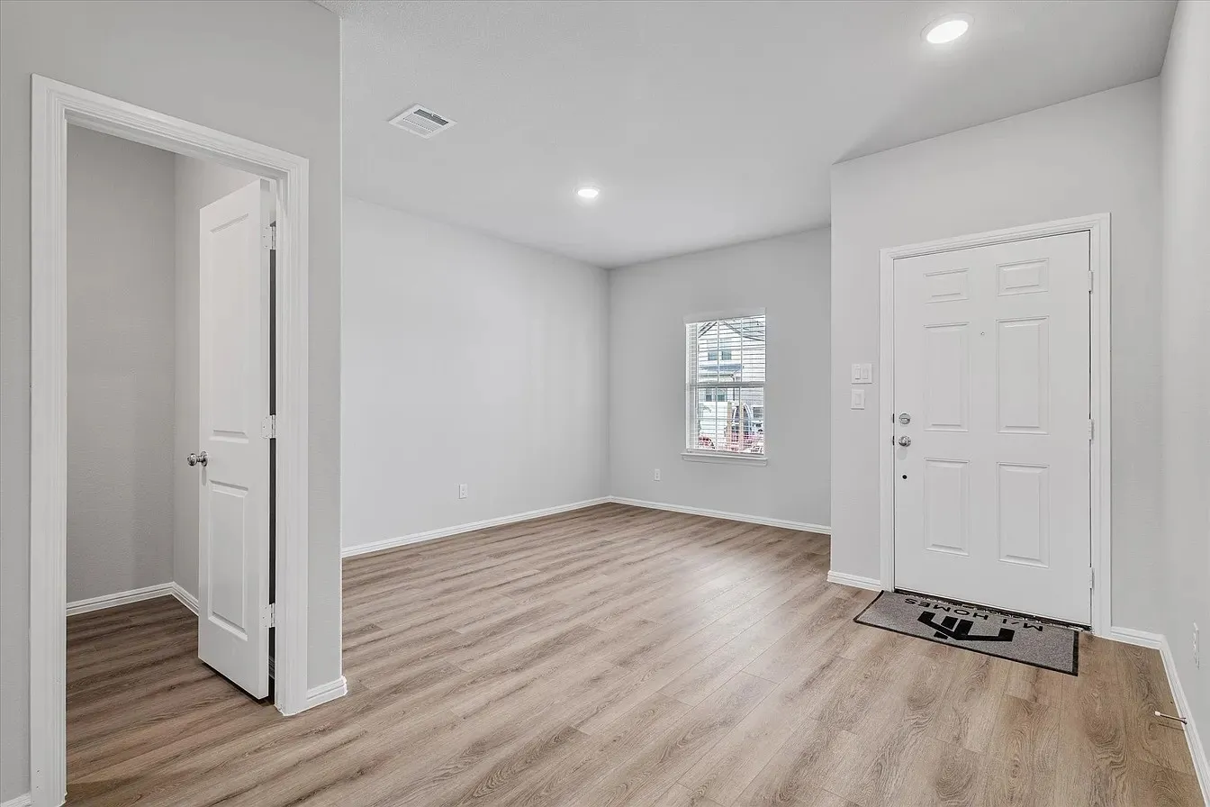 Entryway featuring wood-finish flooring, recessed lighting, and a paneled front door