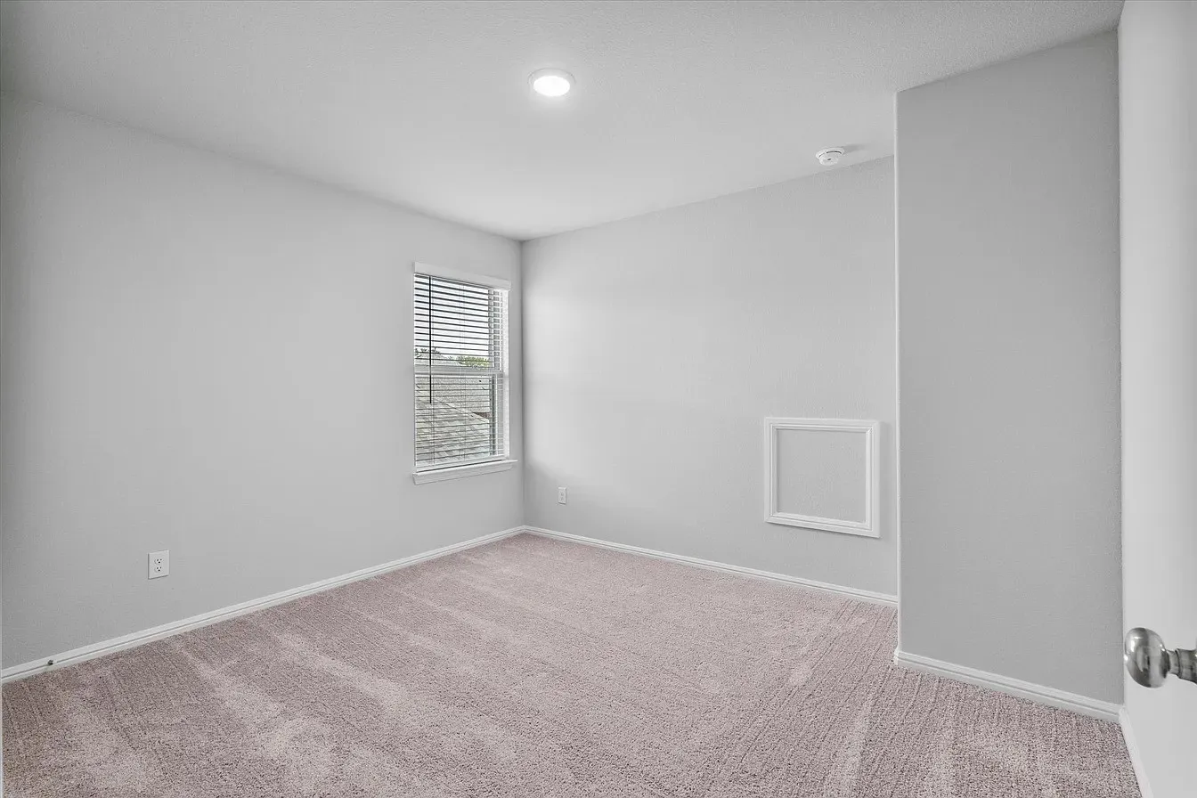 Room featuring neutral carpet flooring, a window with horizontal blinds, and recessed ceiling lighting