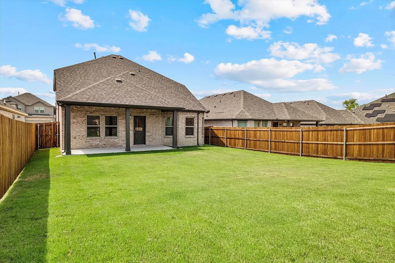 Expansive green lawn with a newly installed wooden privacy fence