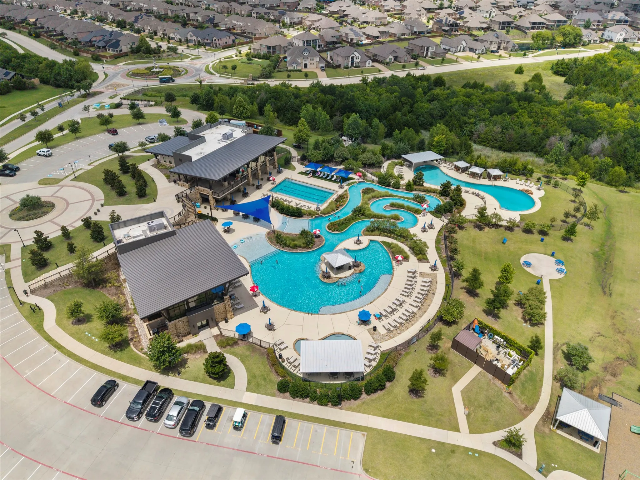 Expansive aquatic amenities featuring a multi-pool complex, winding lazy river, and multiple shaded lounge areas