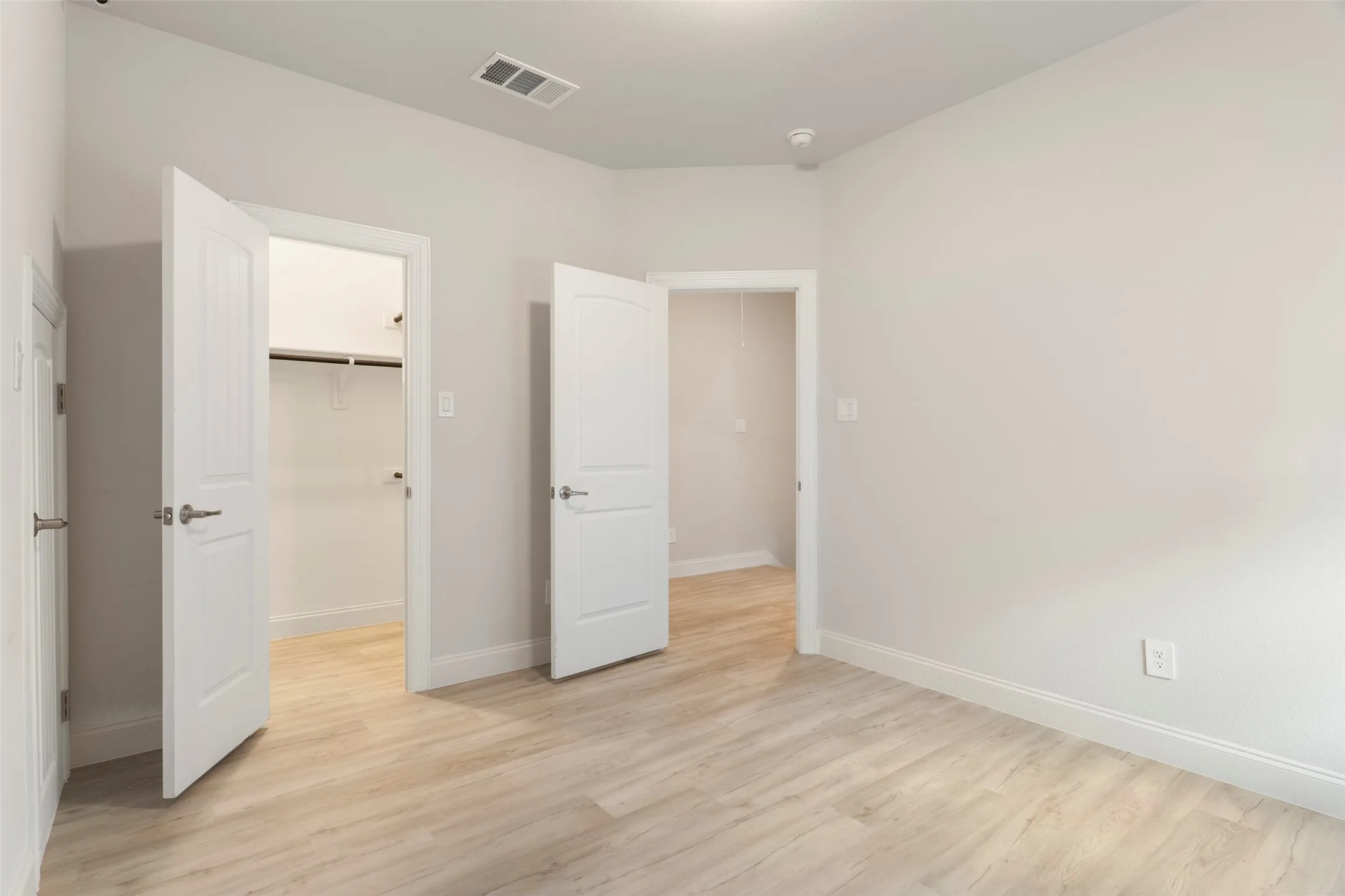 Light wood-finish flooring complements the neutral wall tones