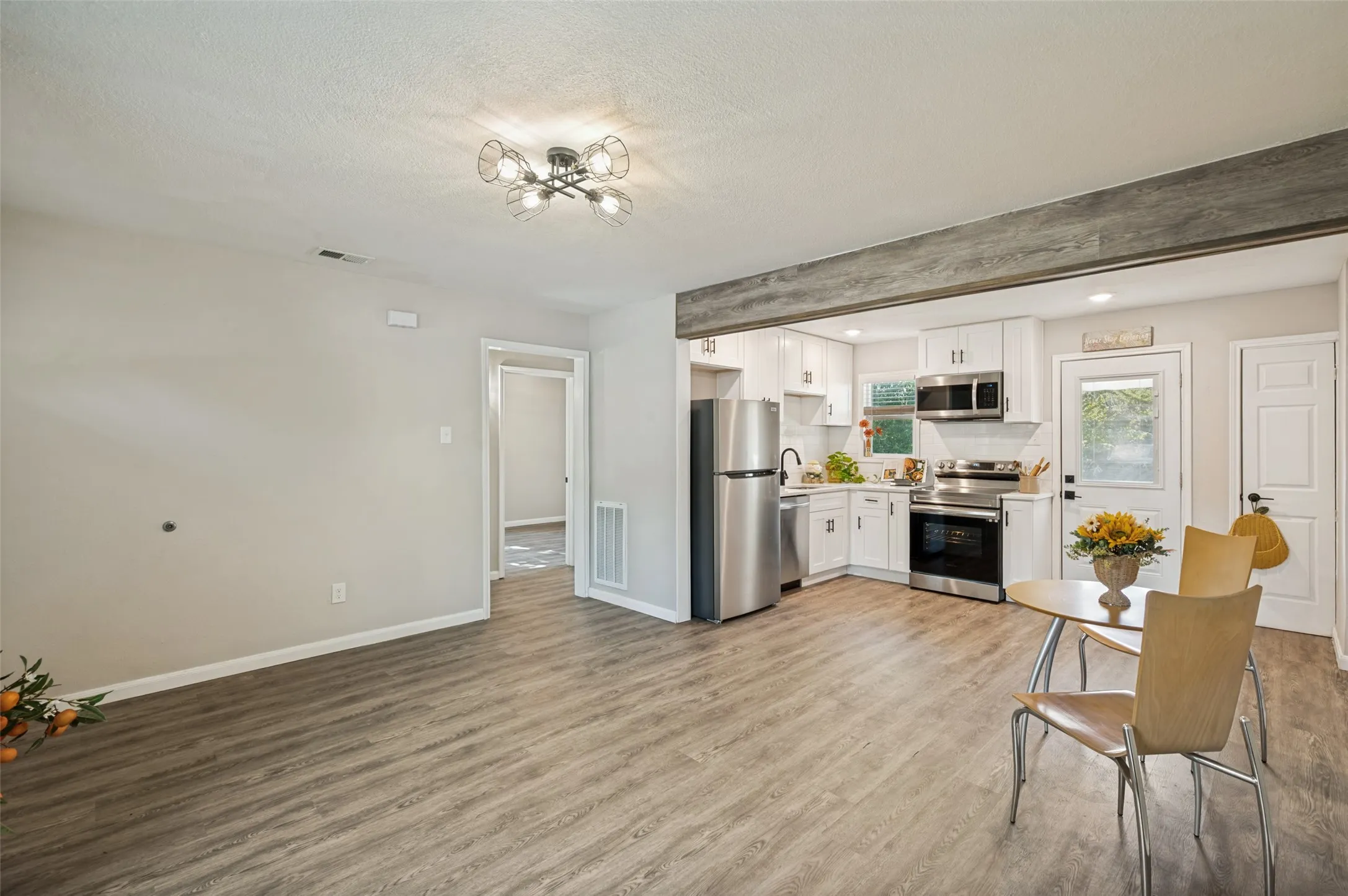 Roomy Great Room with modern appliances, including a refrigerator, range, microwave.