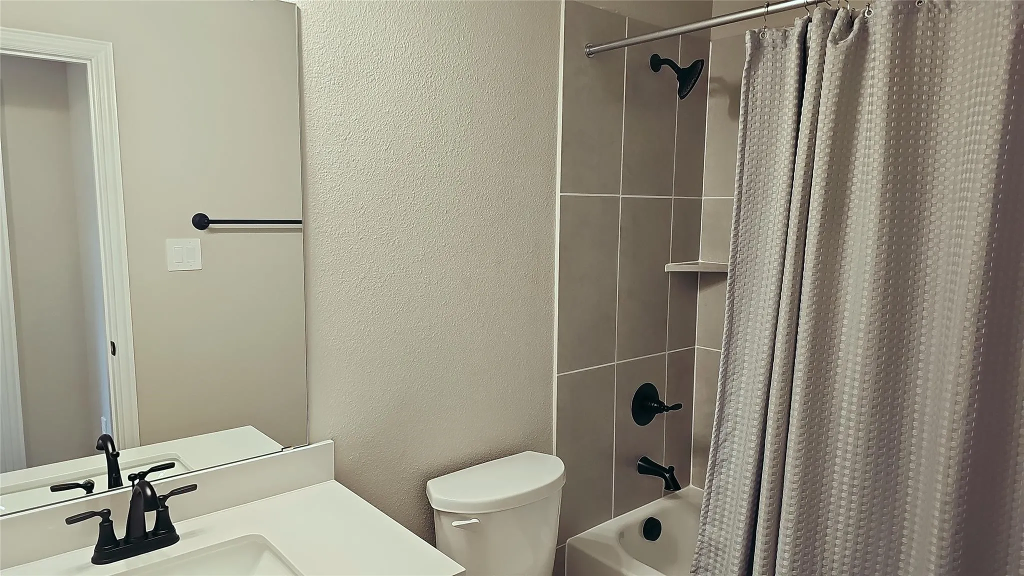 Bathroom featuring a white vanity with an integrated sink, matte black faucet, and a large frameless mirror
