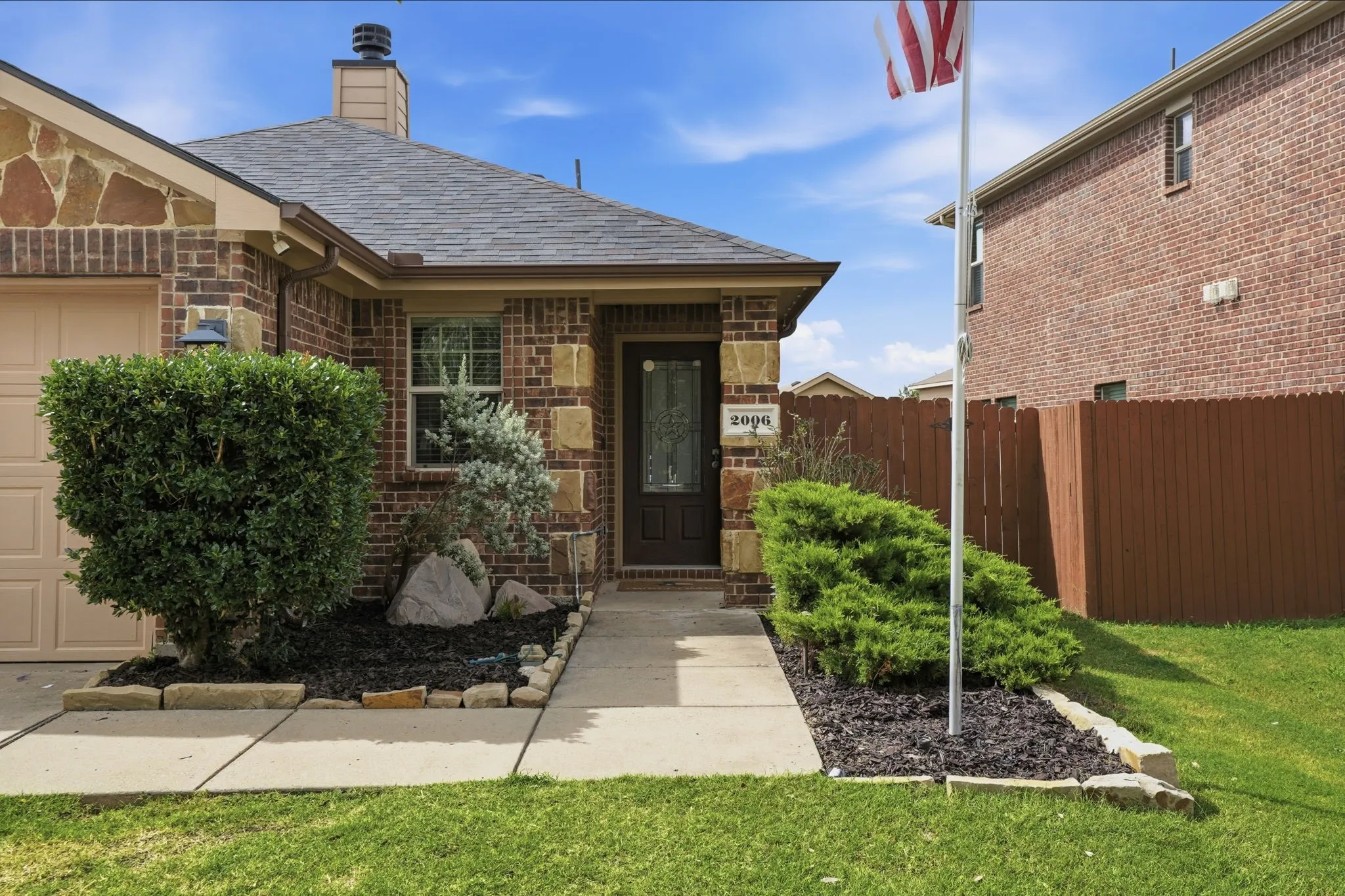 Brick exterior featuring stone accents and a covered entry