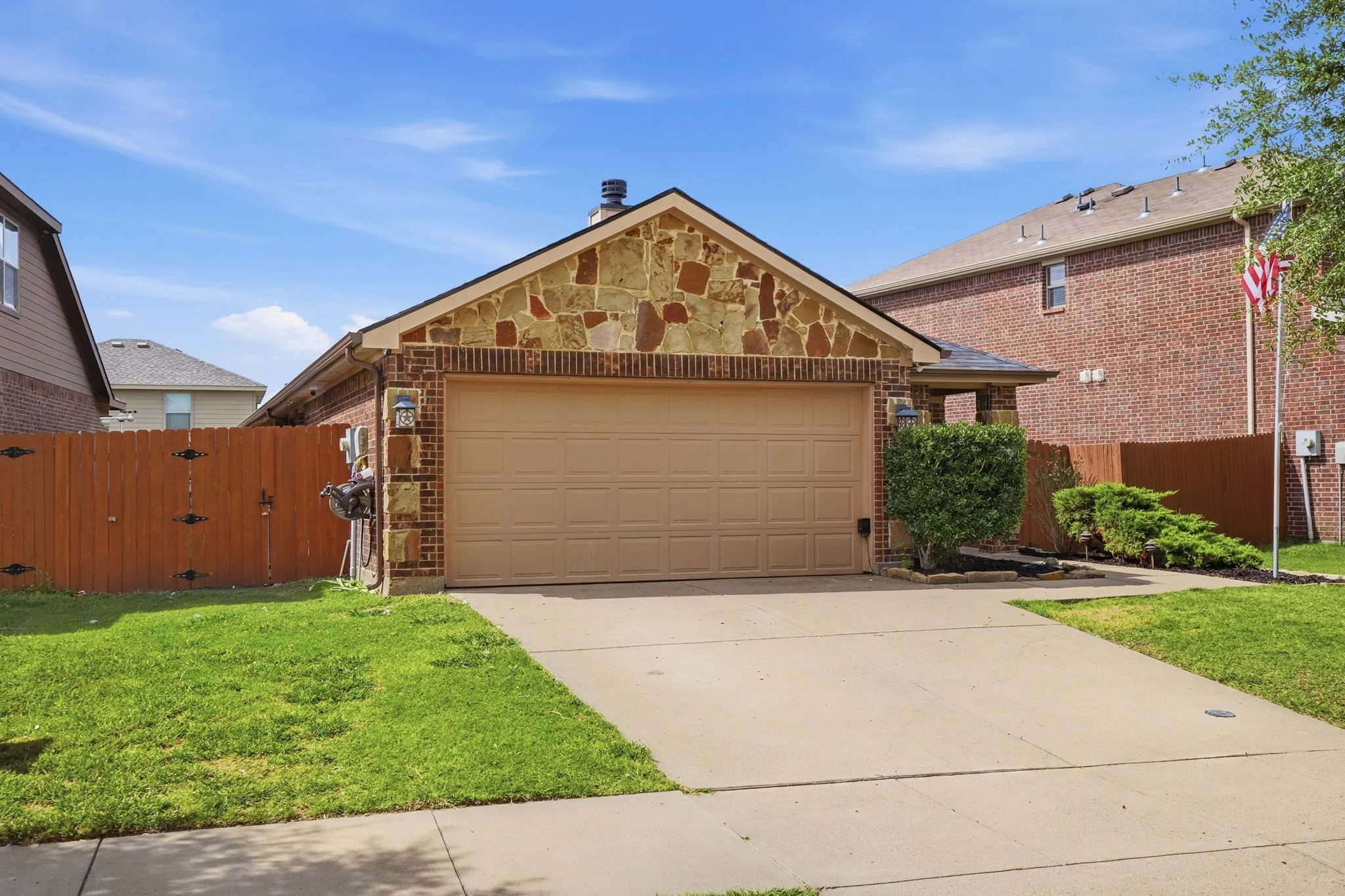 Brick exterior featuring a stone facade and an attached two-car garage