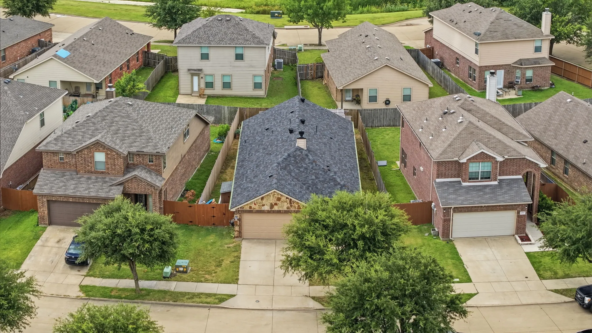 Two-story home with a brick and stone facade, featuring an attached garage and a gabled roof