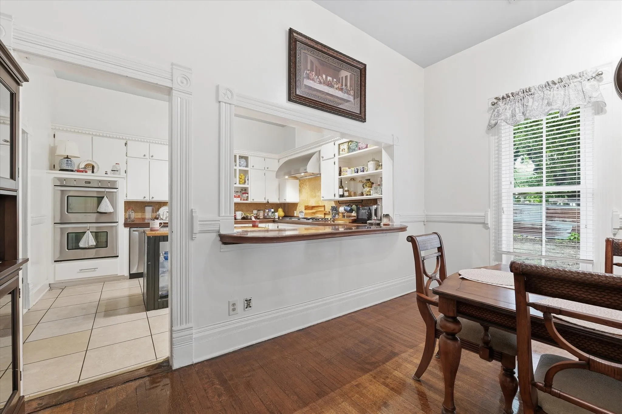 Entryway from dining room into kitchen with pass-through mahogany buffet