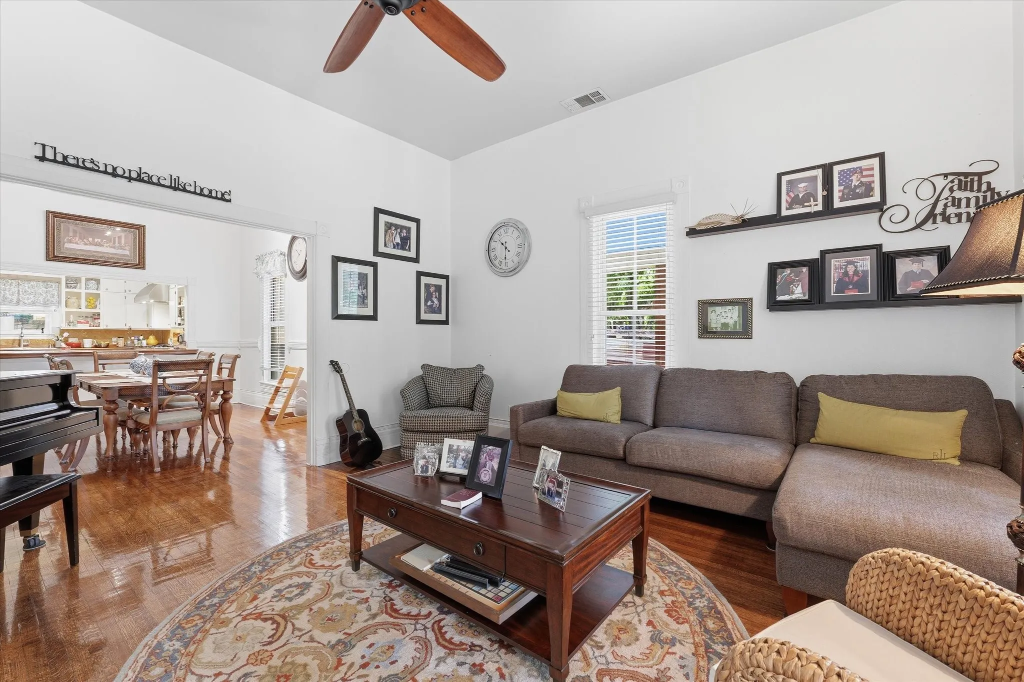Vast living space with 12' ceilings, oak wood flooring, and a ceiling fan