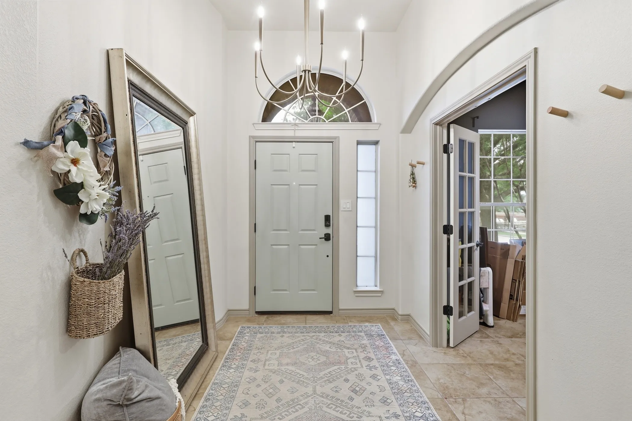 Inviting wide entry and French doors to office.