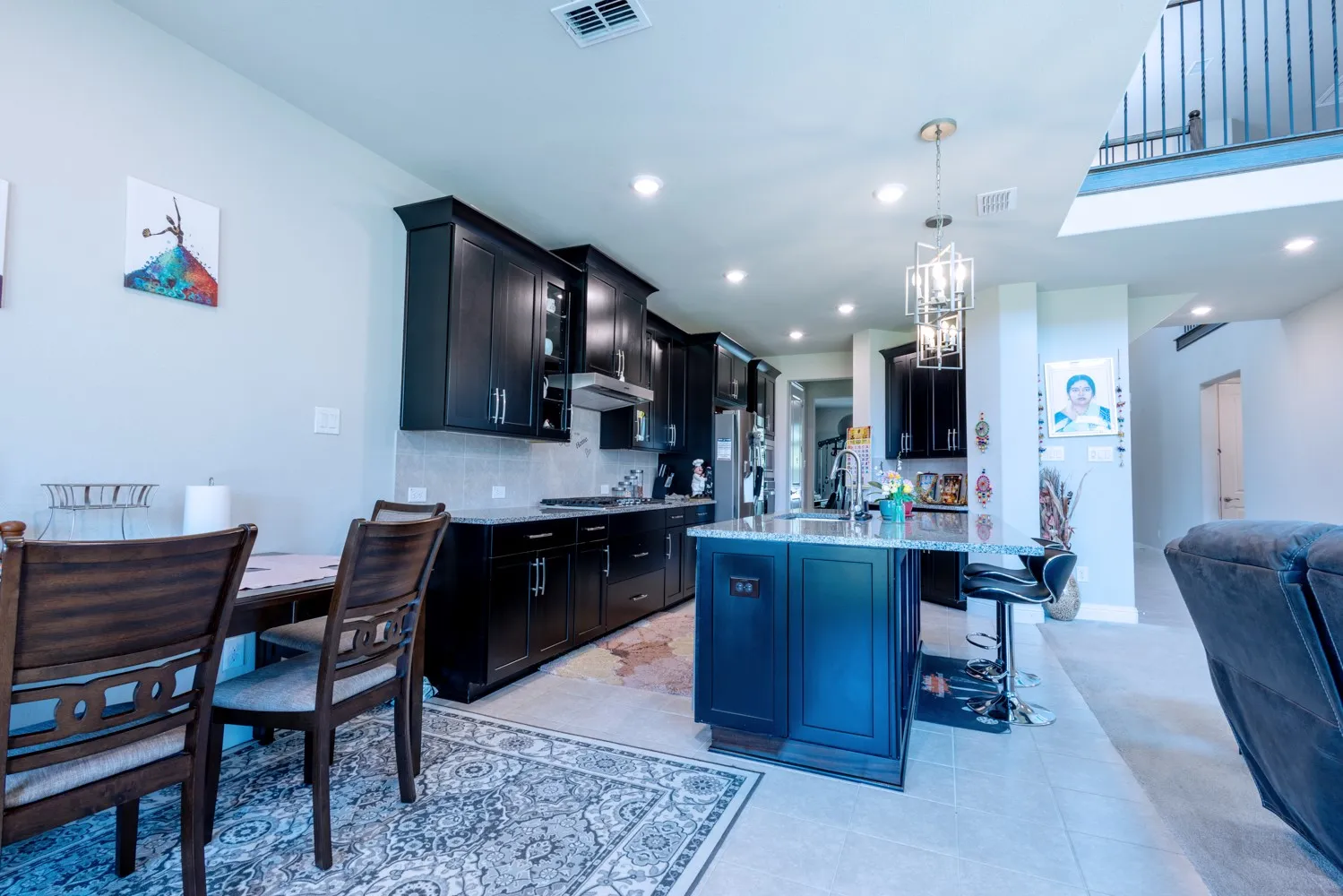 Modern kitchen featuring dark cabinetry, stainless steel appliances, a center island with bar seating, and recessed lighting