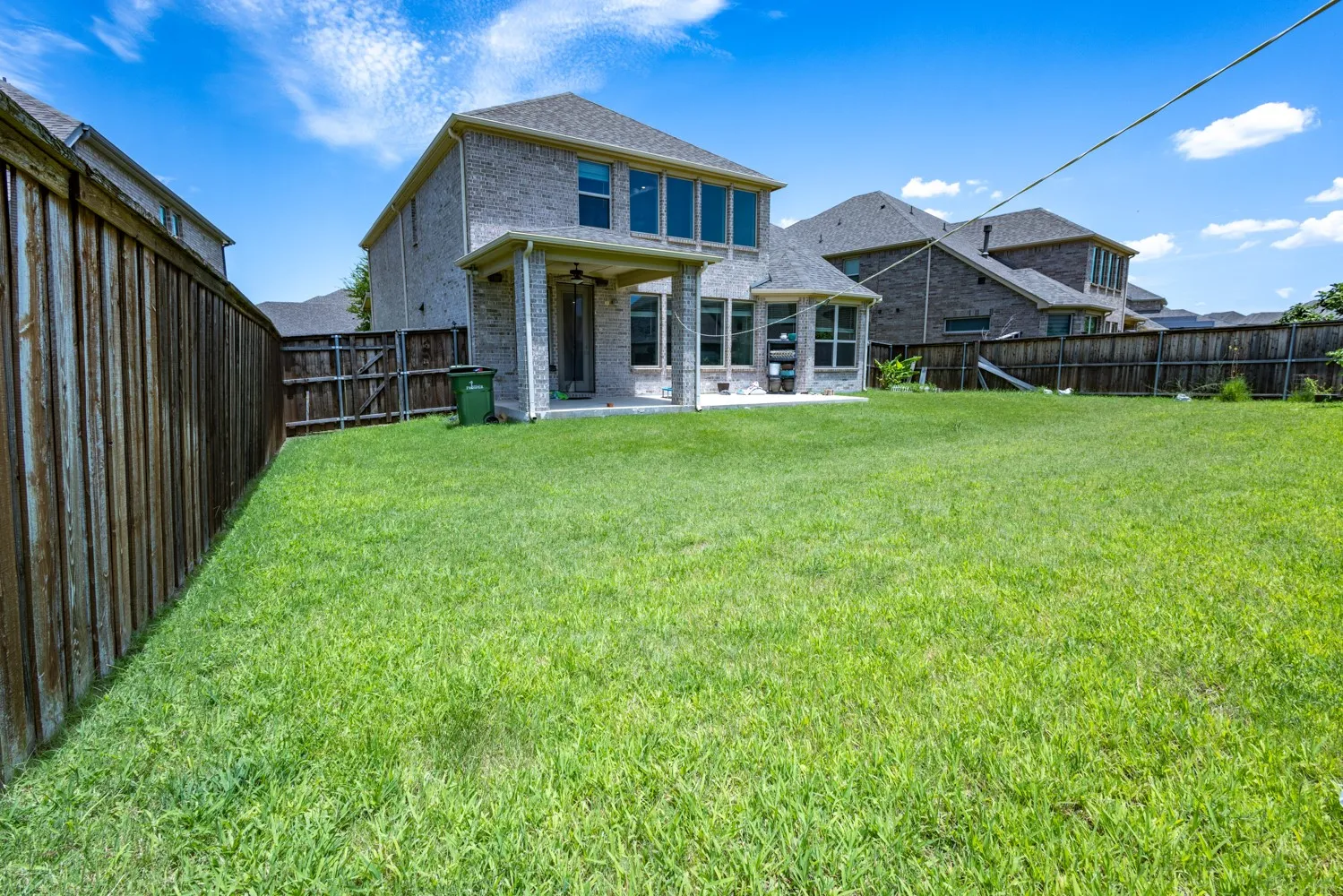 Expansive green lawn with a two-story brick exterior