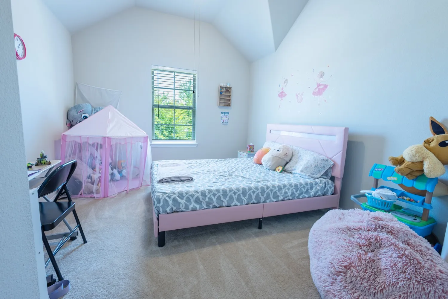 Carpeted room featuring a vaulted ceiling, a single window with blinds, and light-toned walls