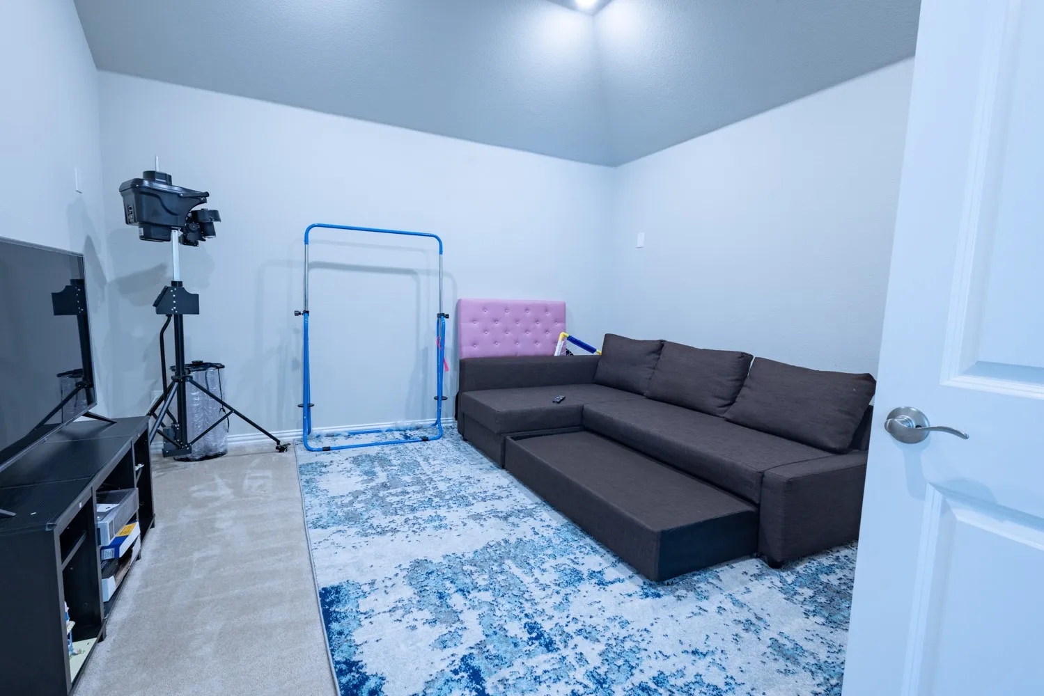 Carpeted room with light neutral wall paint, recessed lighting, and a white interior door with brushed nickel hardware