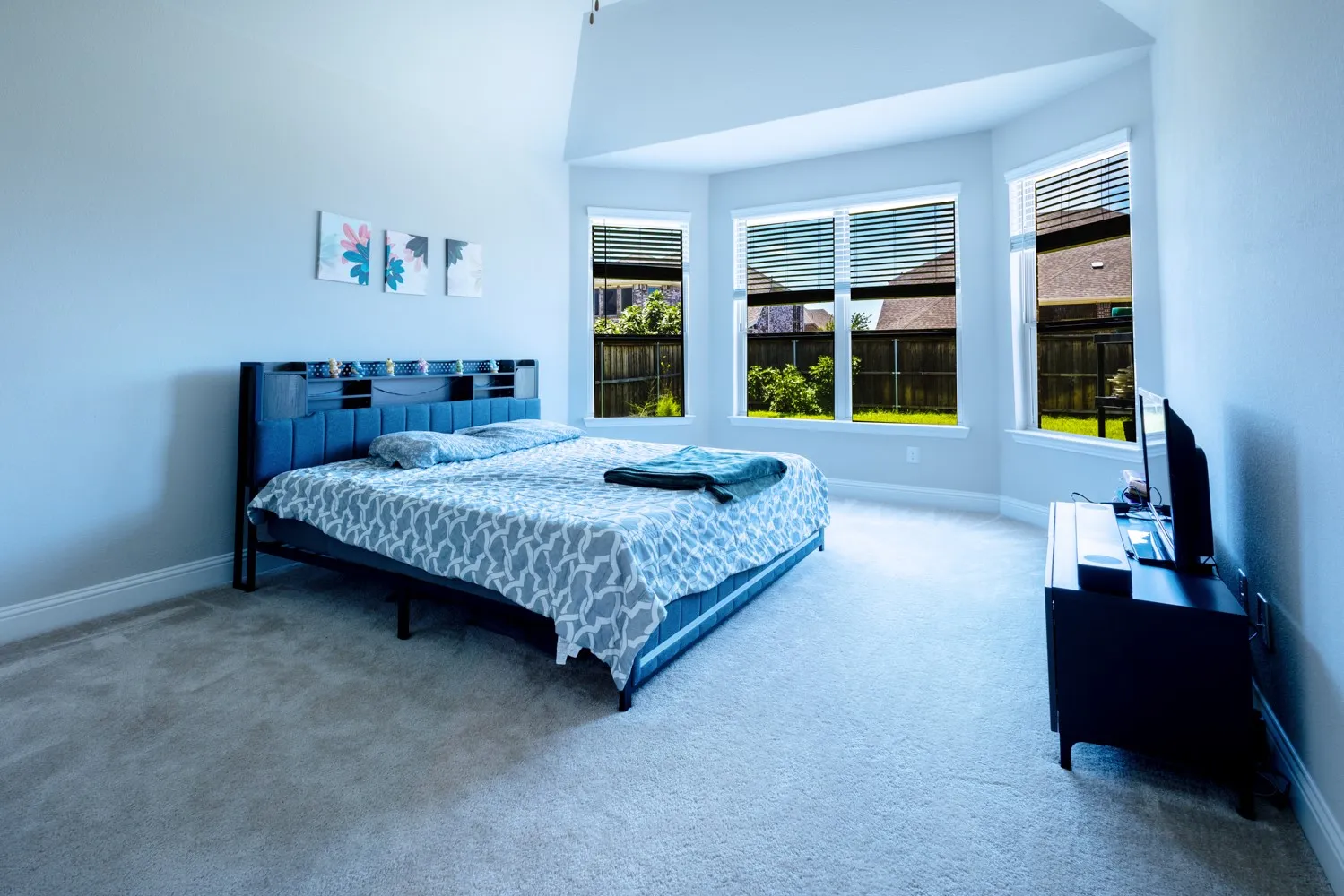 Carpeted room with vaulted ceiling and three large​​‌​​​​‌​​‌‌​‌‌​​​‌‌​‌​‌​‌​​​‌​​ windows