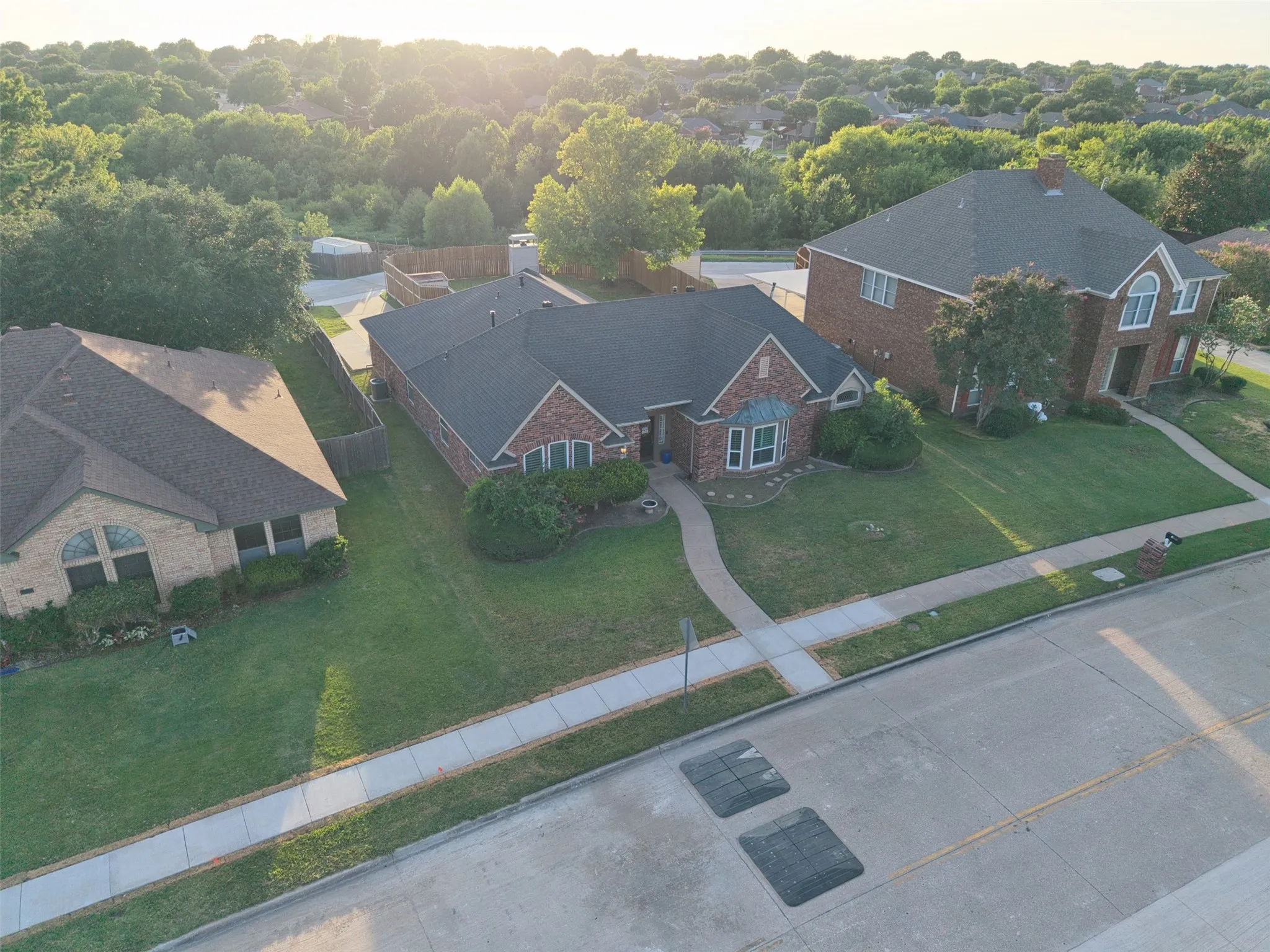 Brick-clad residence featuring a gabled roofline and landscaped front yard