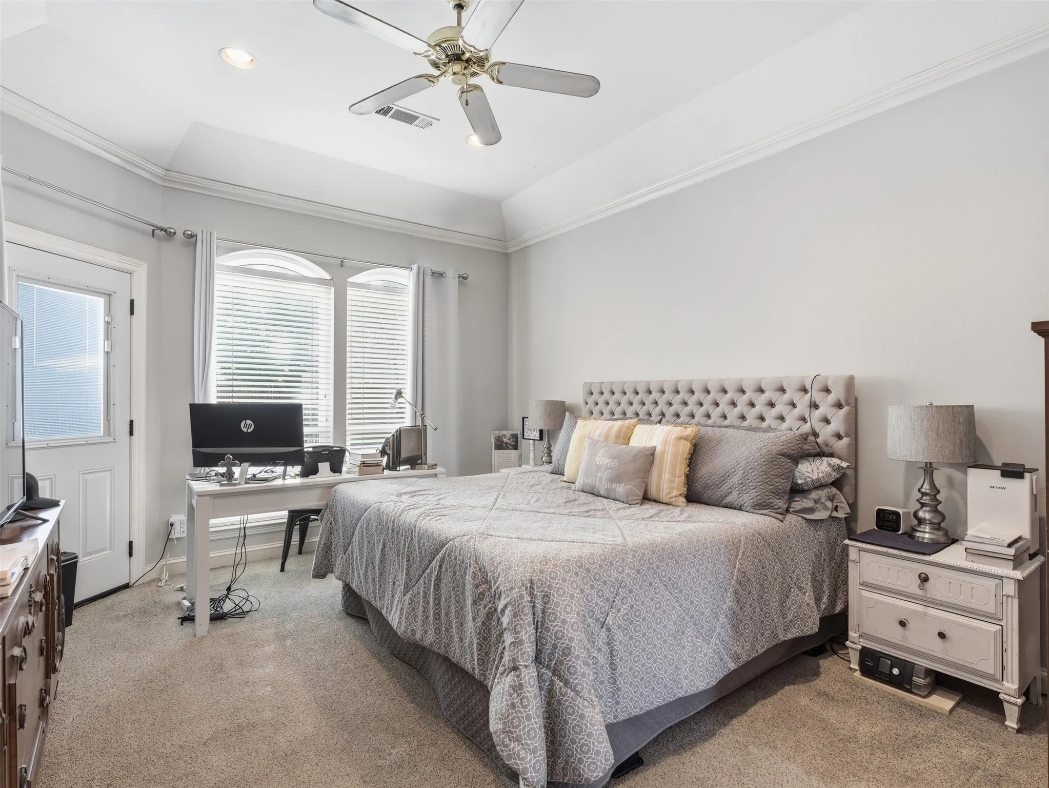 Carpeted Primary bedroom featuring a ceiling fan, recessed lighting, crown molding, and a vaulted ceiling