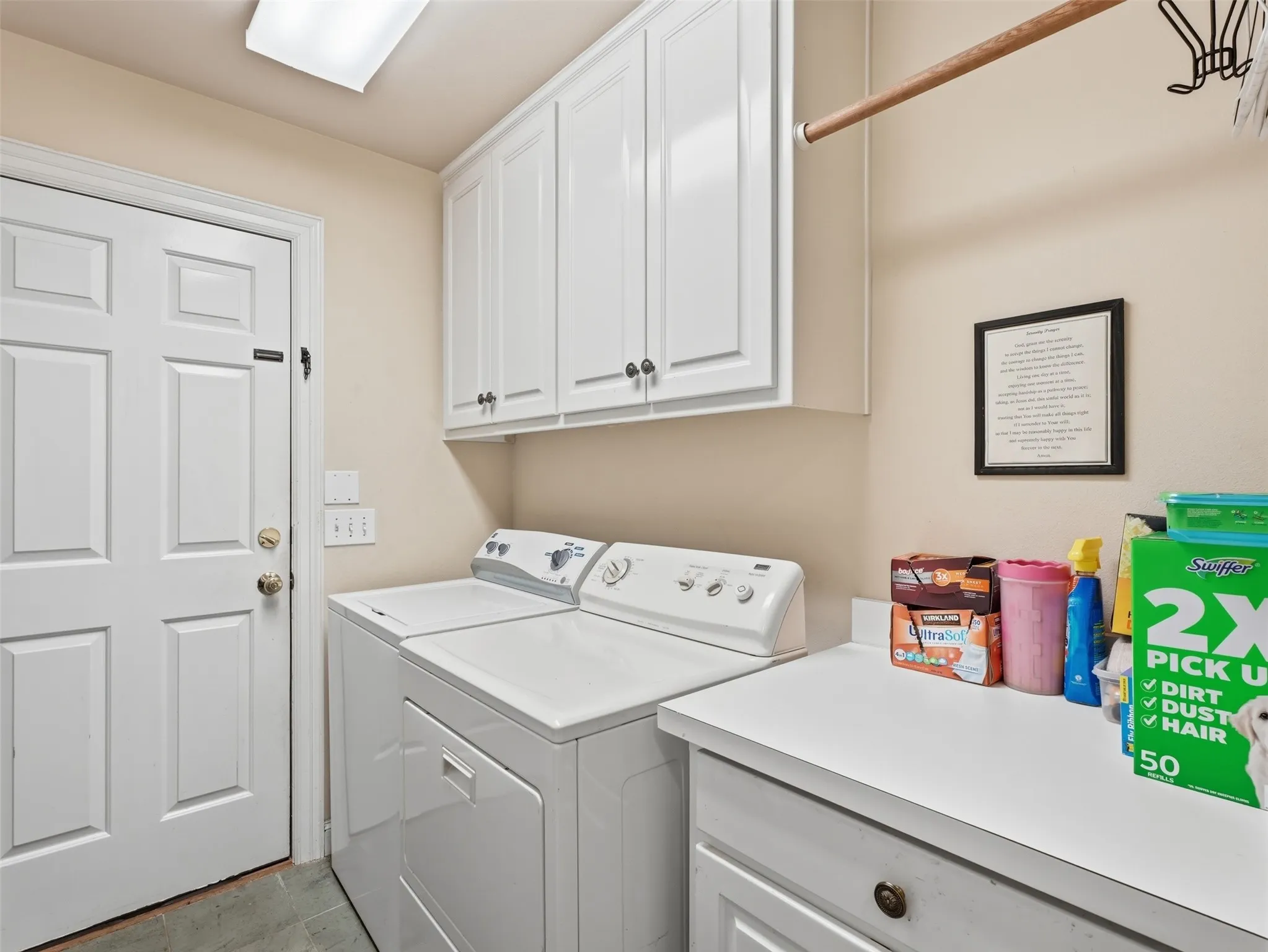 Dedicated laundry area featuring white shaker-style cabinetry, a built-in counter surface, a utility rod, and square ceiling lighting