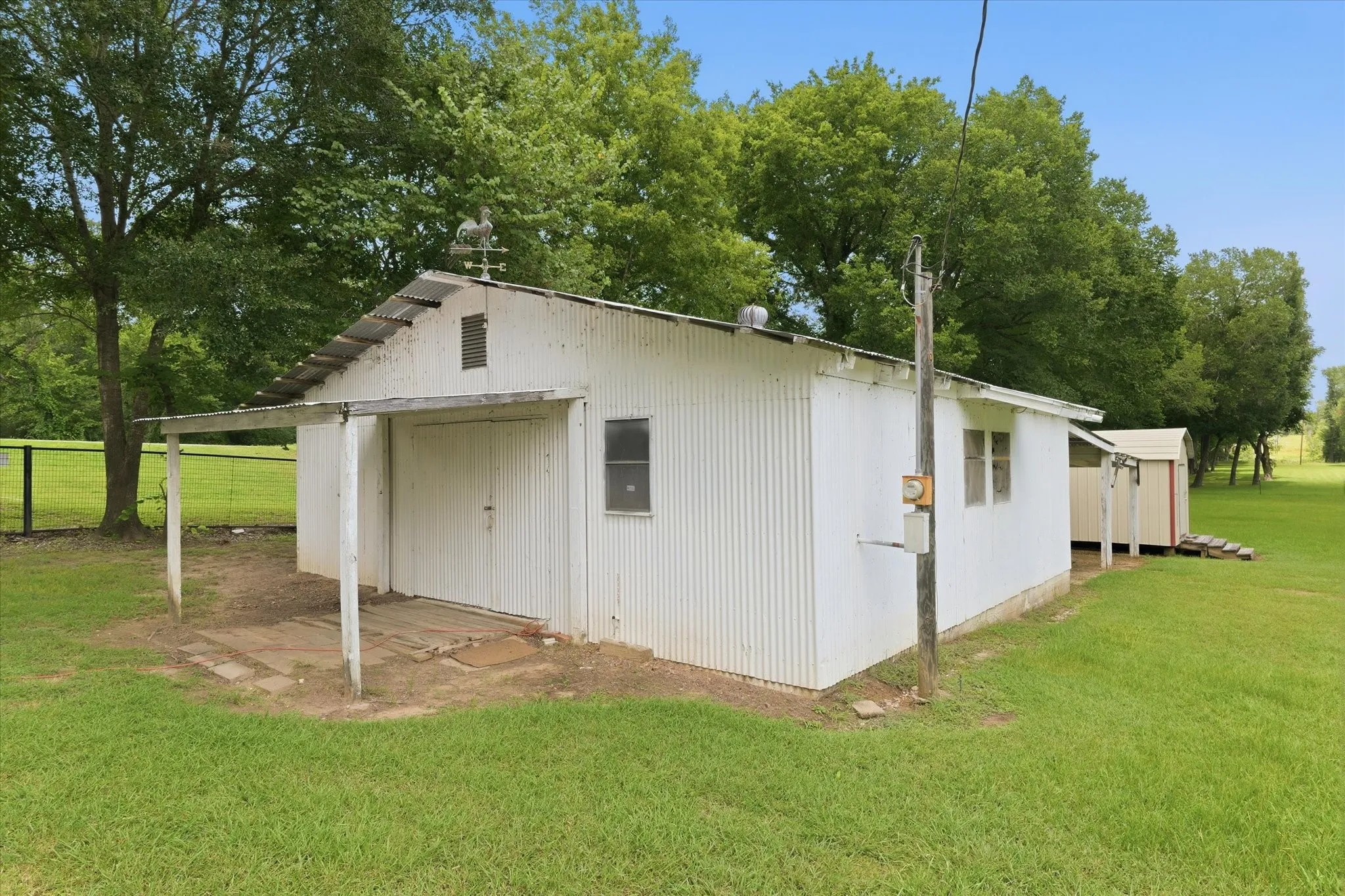 Spacious workshop sits on a slab with electricity in place and attached covered entry as well as attached carport.