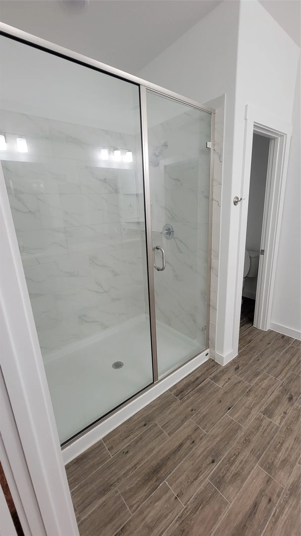 Bathroom featuring an enclosed shower and toilet