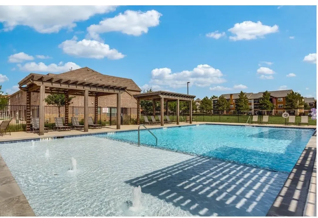 View of pool with a pergola and pool water feature