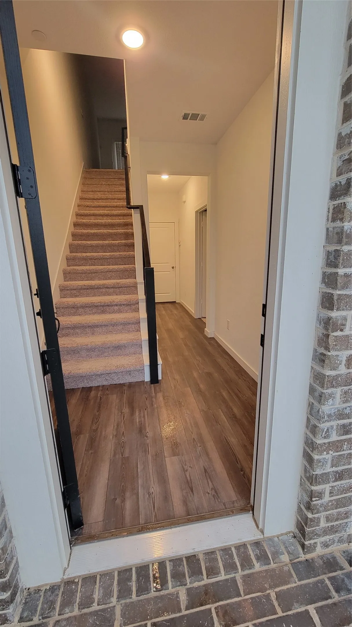 Staircase with dark hardwood / wood-style floors