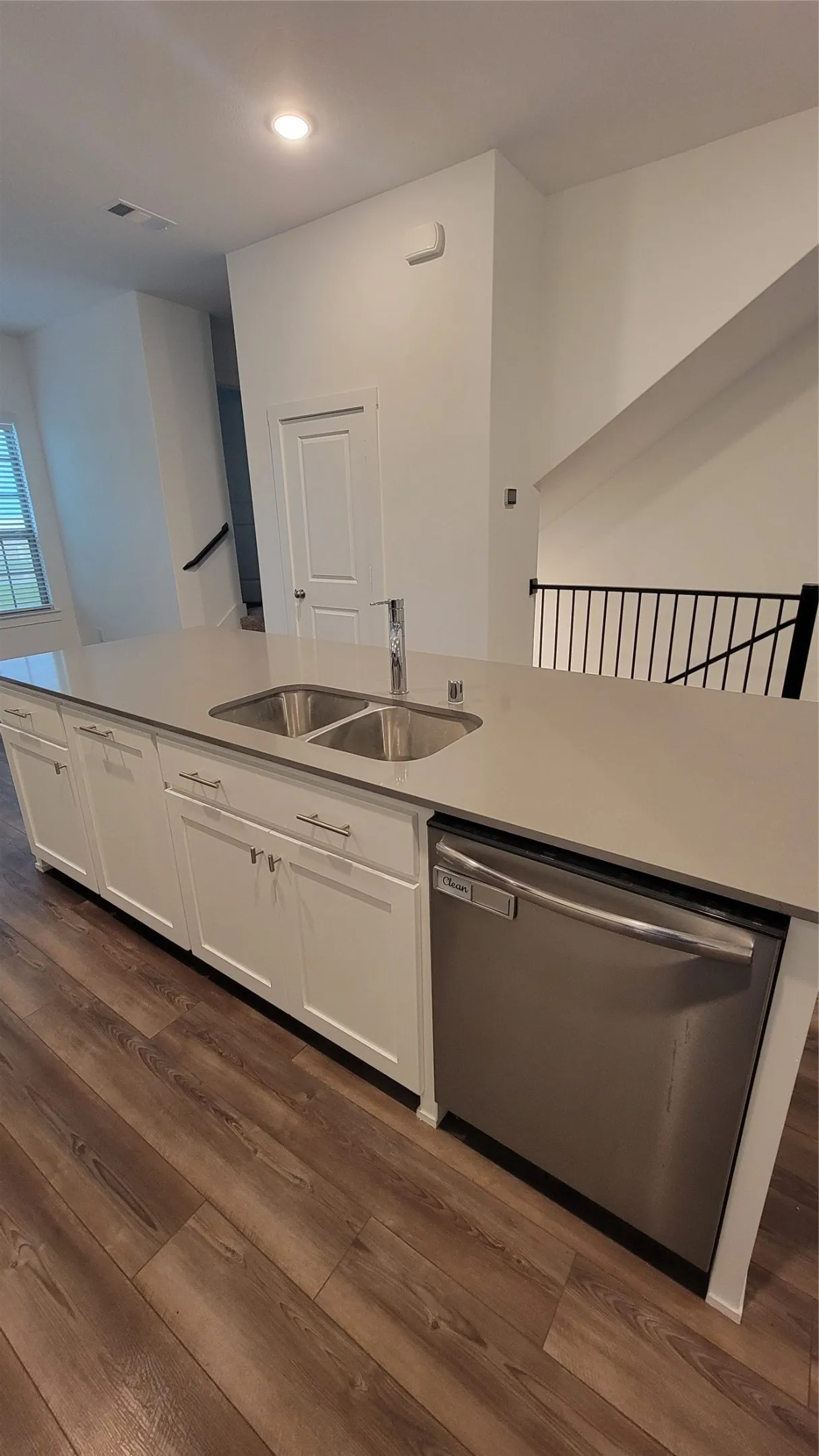 Kitchen with white cabinetry, sink, dark wood-type flooring, and dishwasher