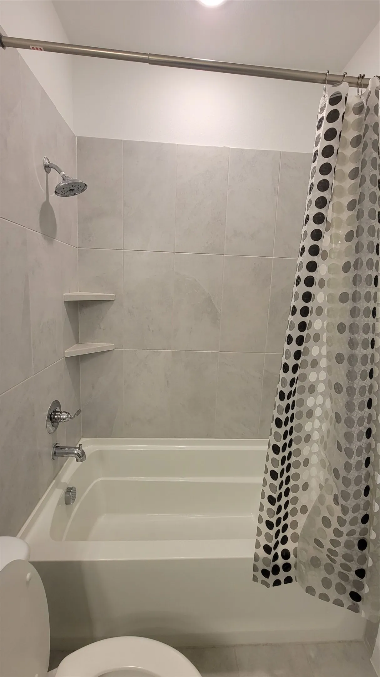 Bathroom with shower / tub combo and toilet