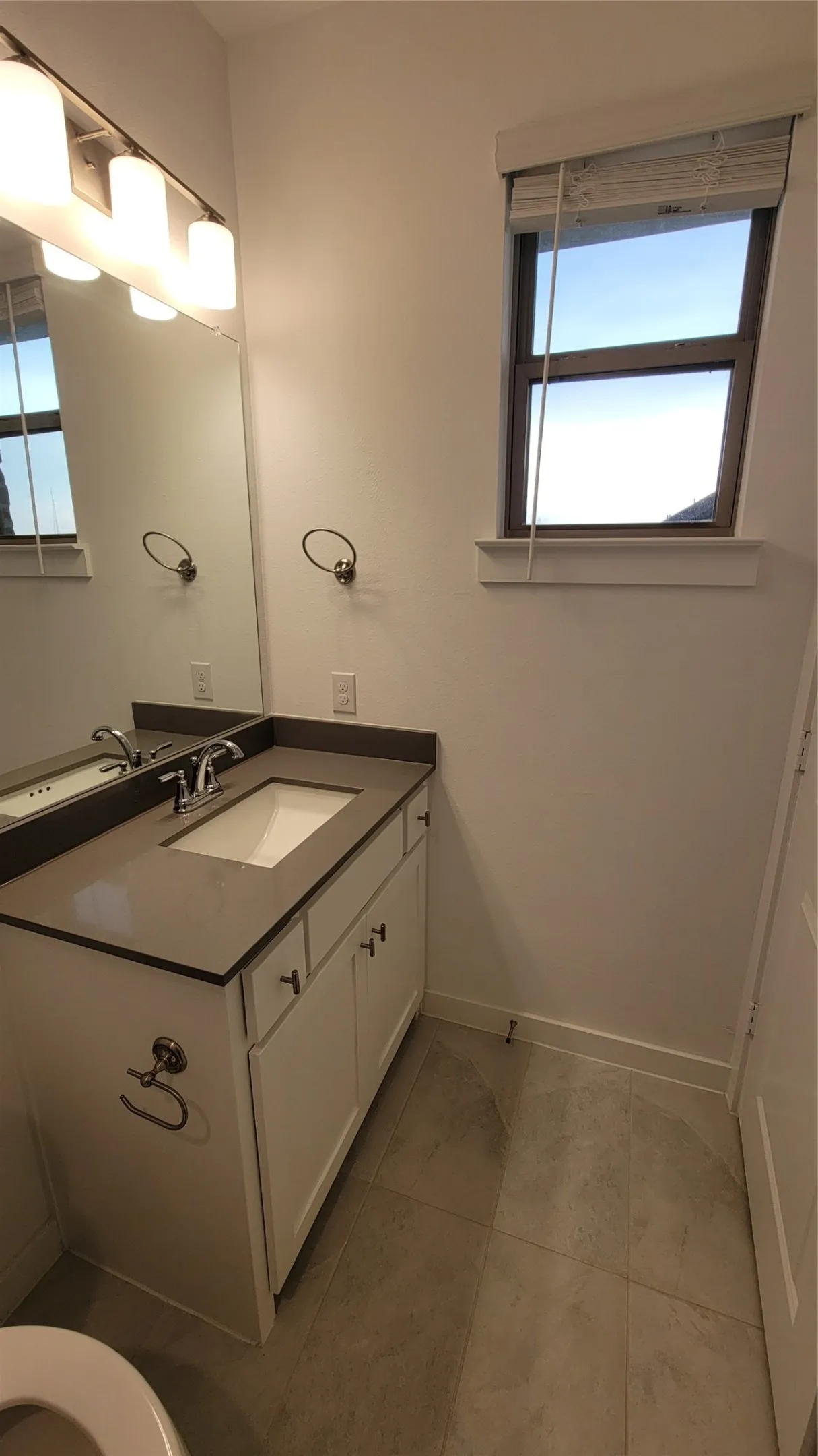Bathroom with a healthy amount of sunlight, vanity, and tile floors