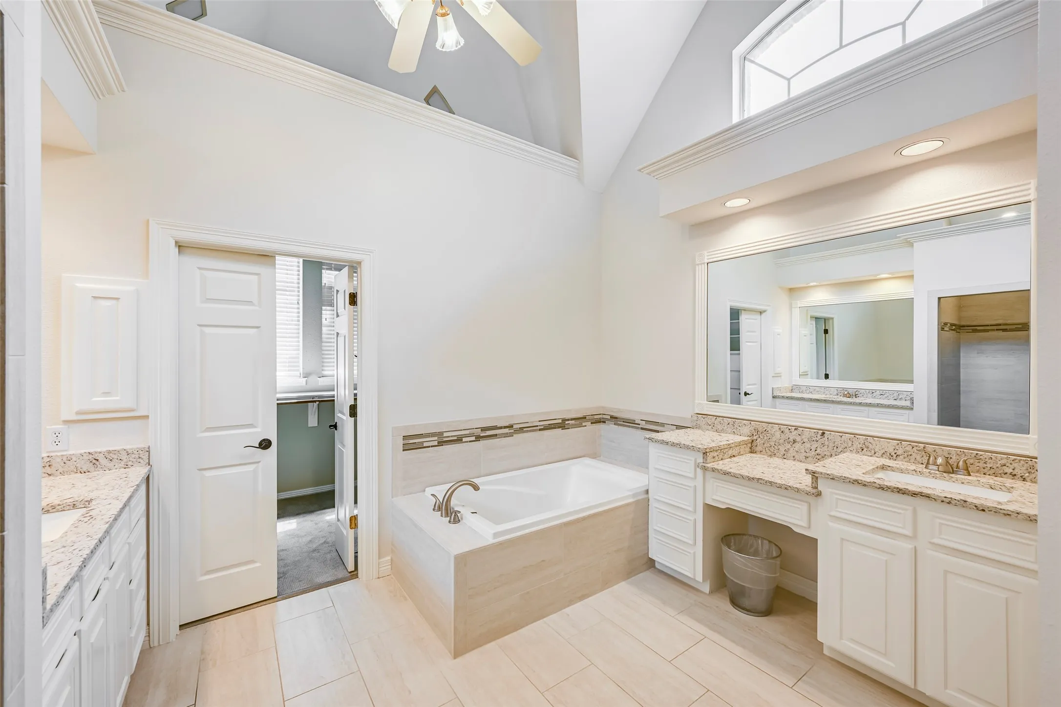 Primary bathroom with separate vanity areas, a walk-in shower, and a large closet.