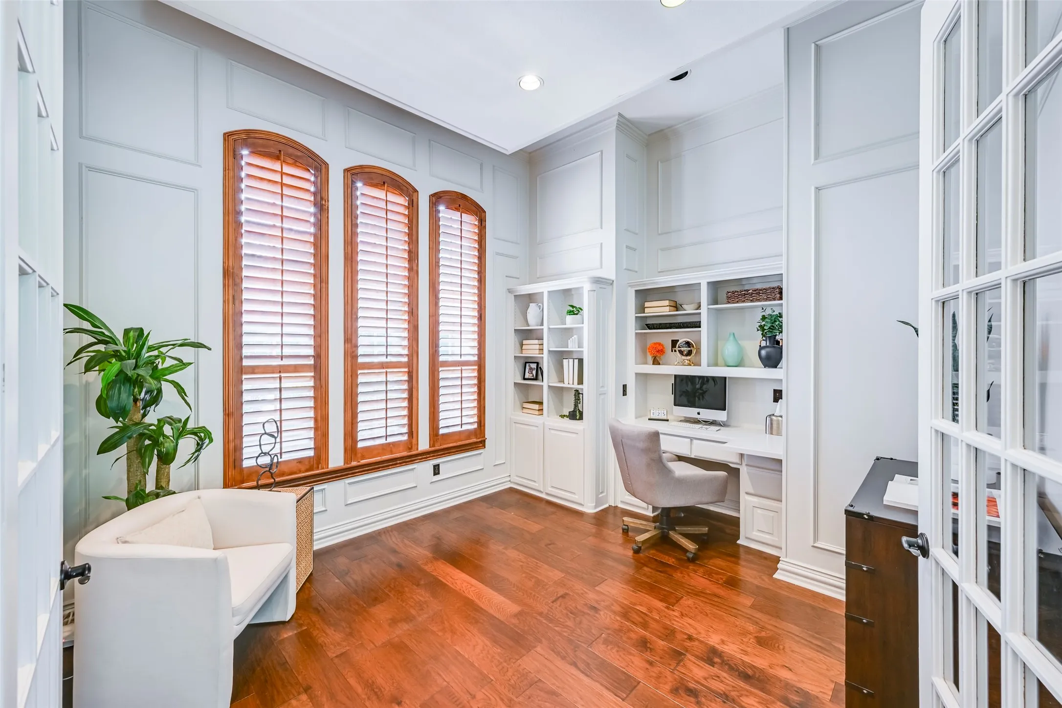 Office with glass-paned French doors, lovely transom window, and built-in desk.