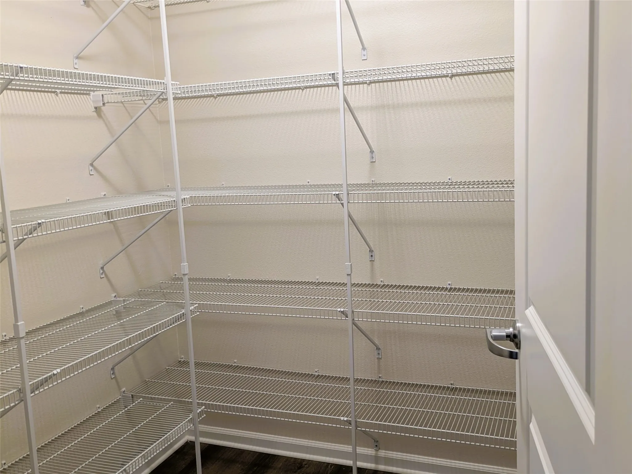 Expansive walk-in pantry featuring white wire shelving system
