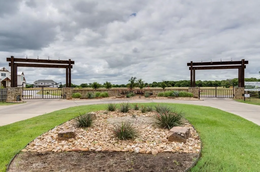 Stone and wood-beam entry gates with wrought iron fencing
