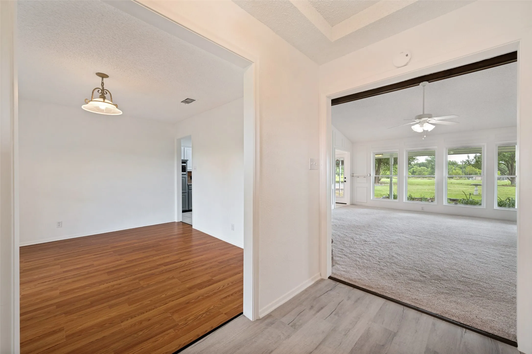 Carpeted front living room and laminate flooring in formal dining room