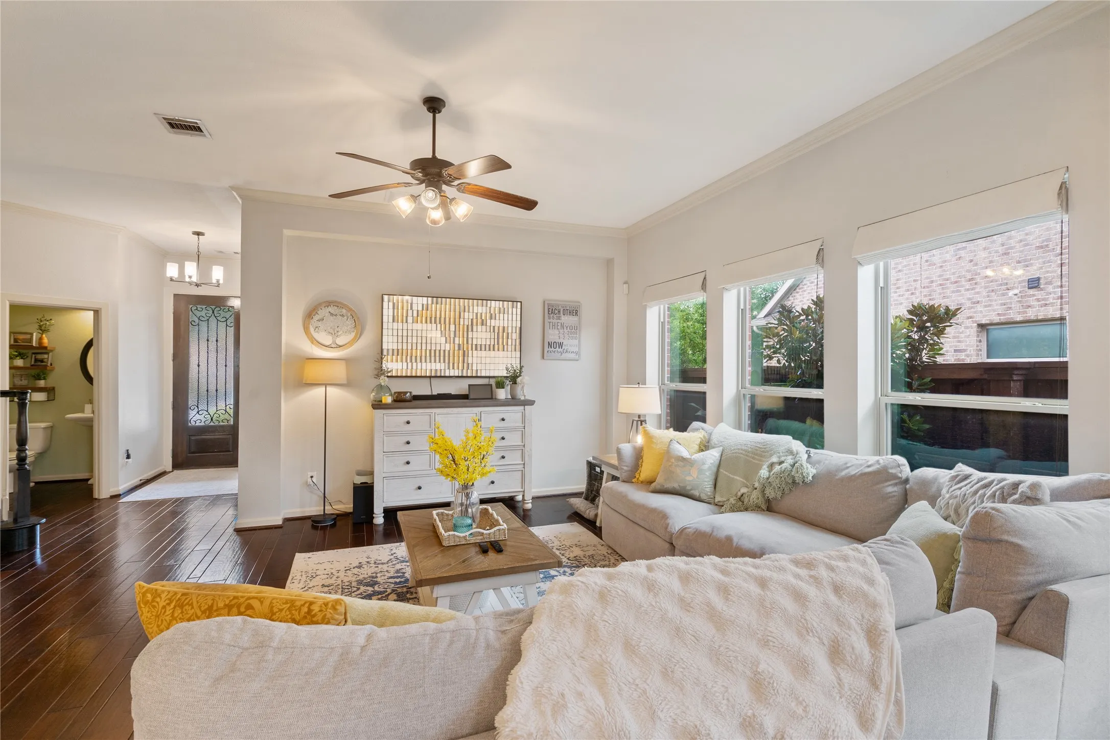 Living area with mahogany wood floors and energy efficient windows with custom shades.