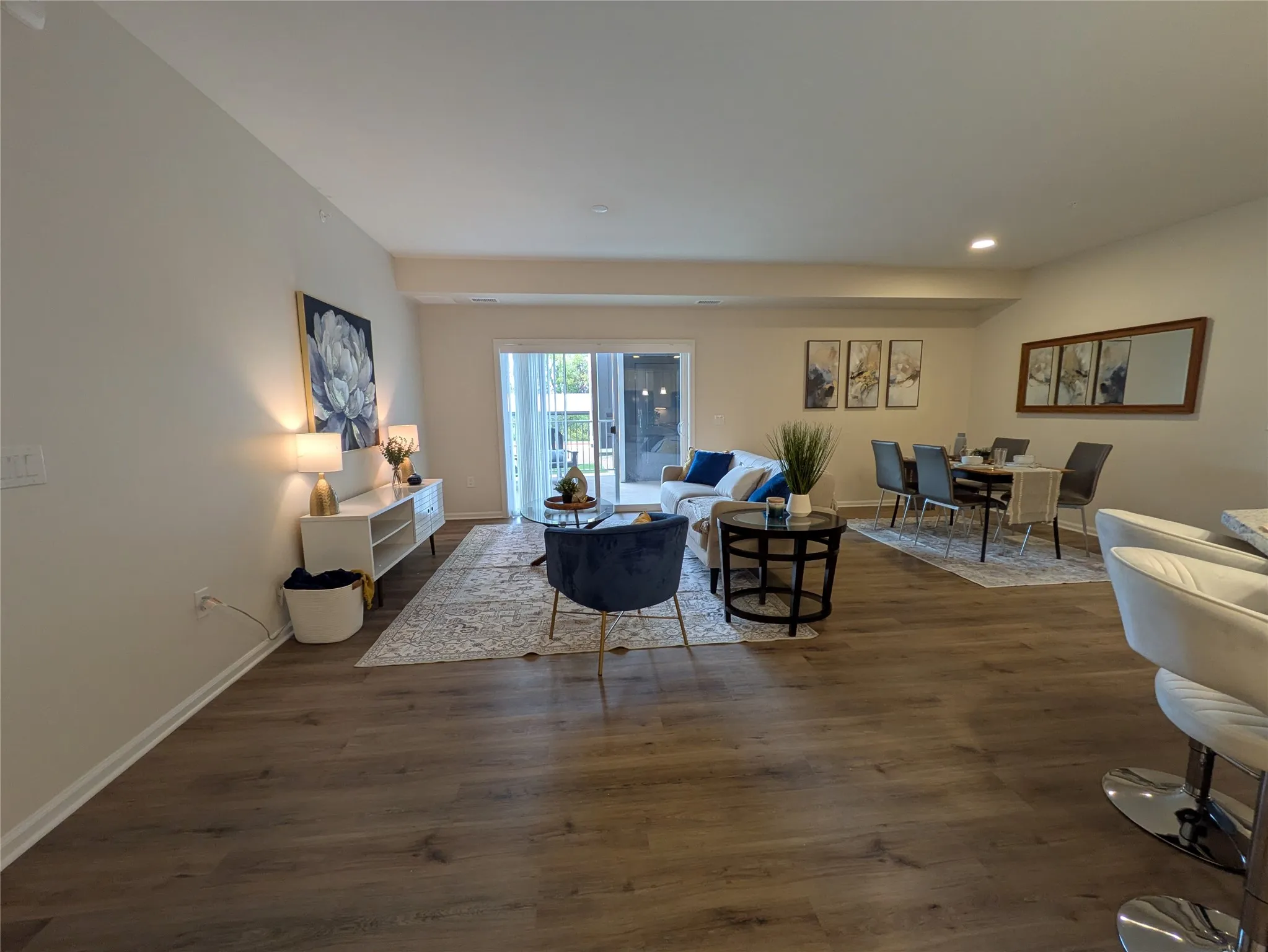 Open-concept living area featuring wood-finish flooring, recessed lighting, and light-toned wall finishes