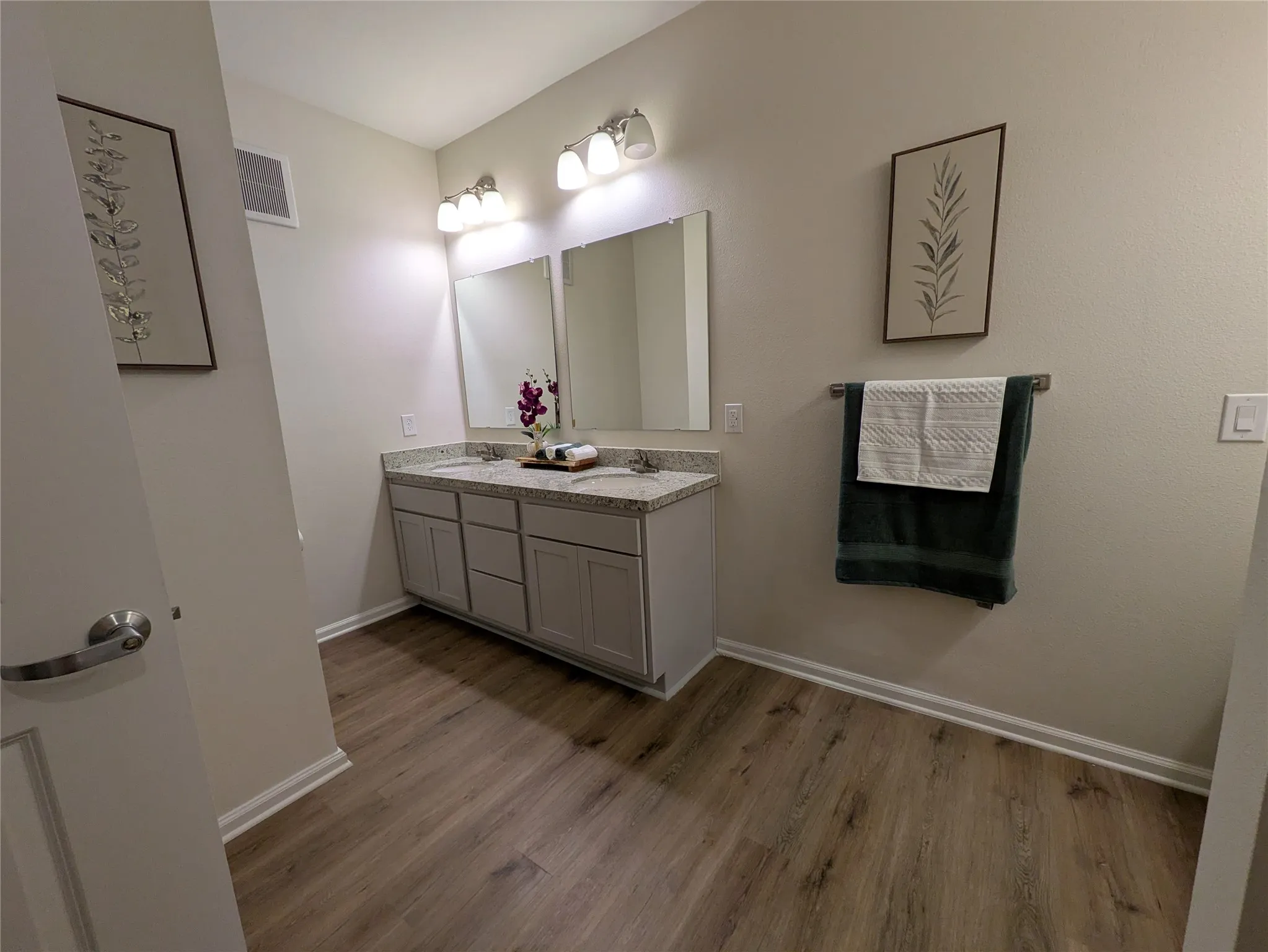 Double vanity with stone-finish countertop, dual integrated sinks, and ample cabinet storage