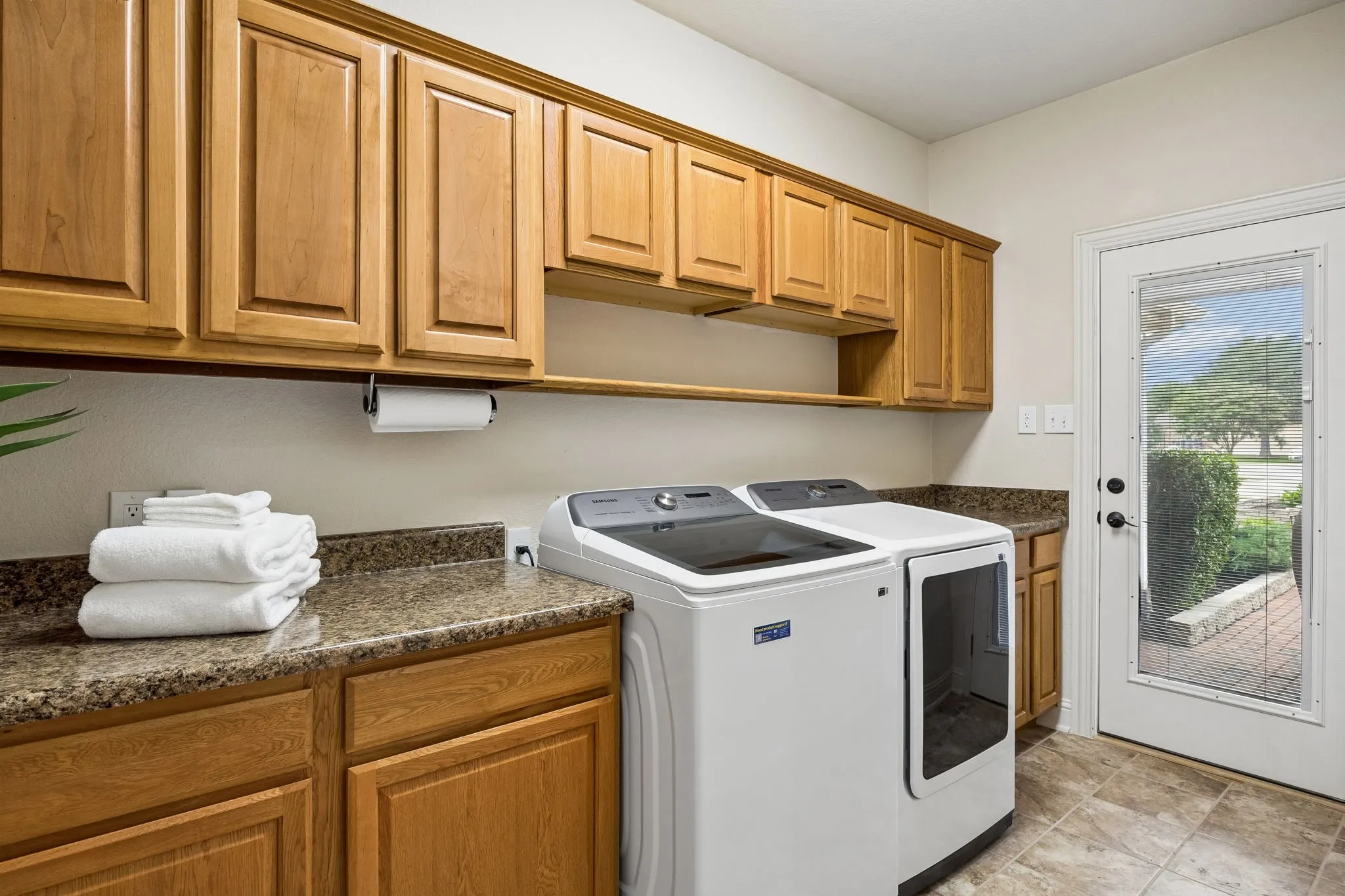 Spacious laundry room off kitchen has great folding space and storage and has access to another private patio.