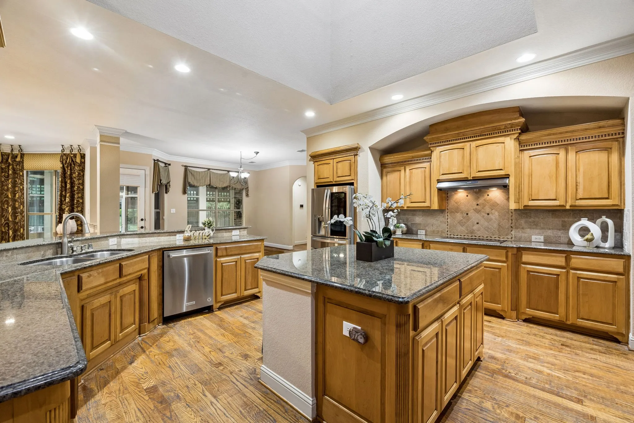 This wonderful kitchen is set up for the chef in us all. Granite countertops with a large island offer abundant workspace. Storage is plentiful with pullout shelving in many of the lower cabinets. In addition to the walk-in pantry in the kitchen, there is a dry pantry in the garage. Other features include stainless appliances, flat surface cooktop, recessed lighting.