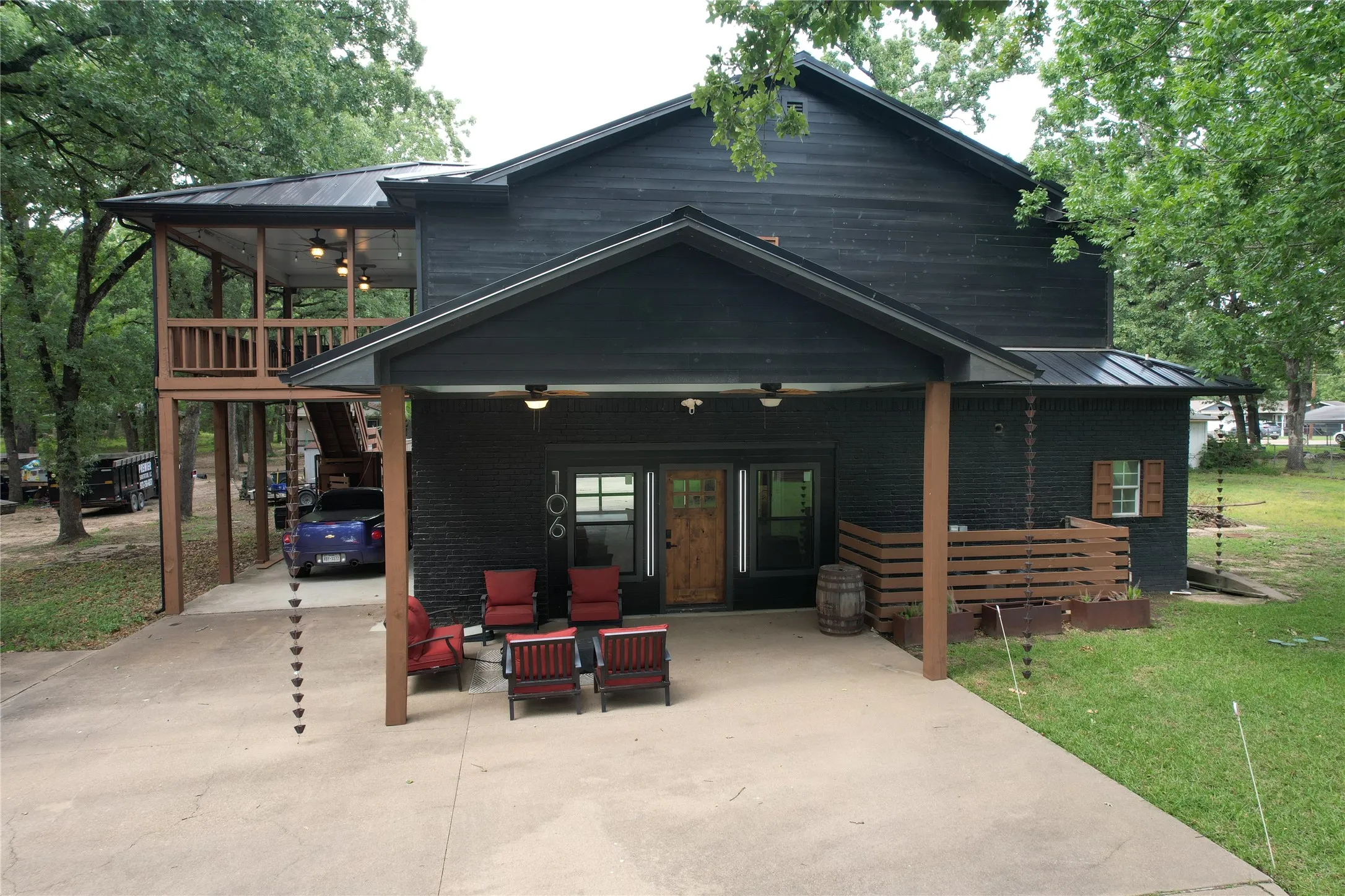 Red Oak Dr house front with spacious covered downstairs Barndo garage living area entrance, plus covered side patio or carport with access to fenced backyard and stairs to upper covered deck.