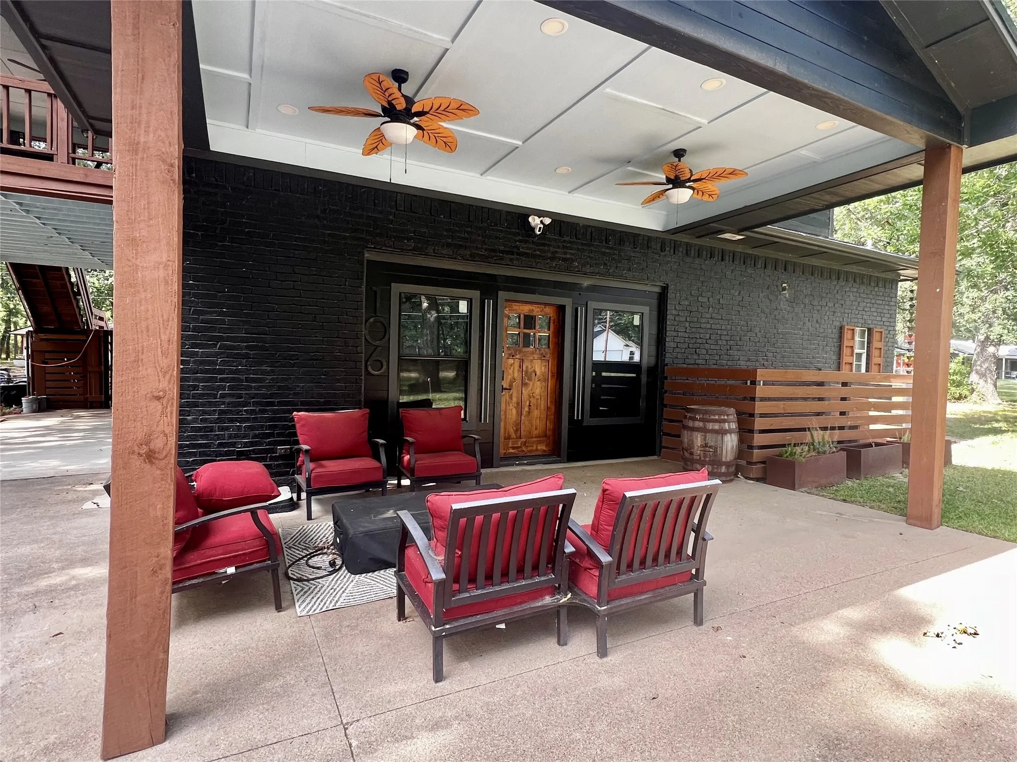 Covered patio with street level access on the Red Oak Dr side of the property featuring a coffered ceiling with recessed lighting and two ceiling fans