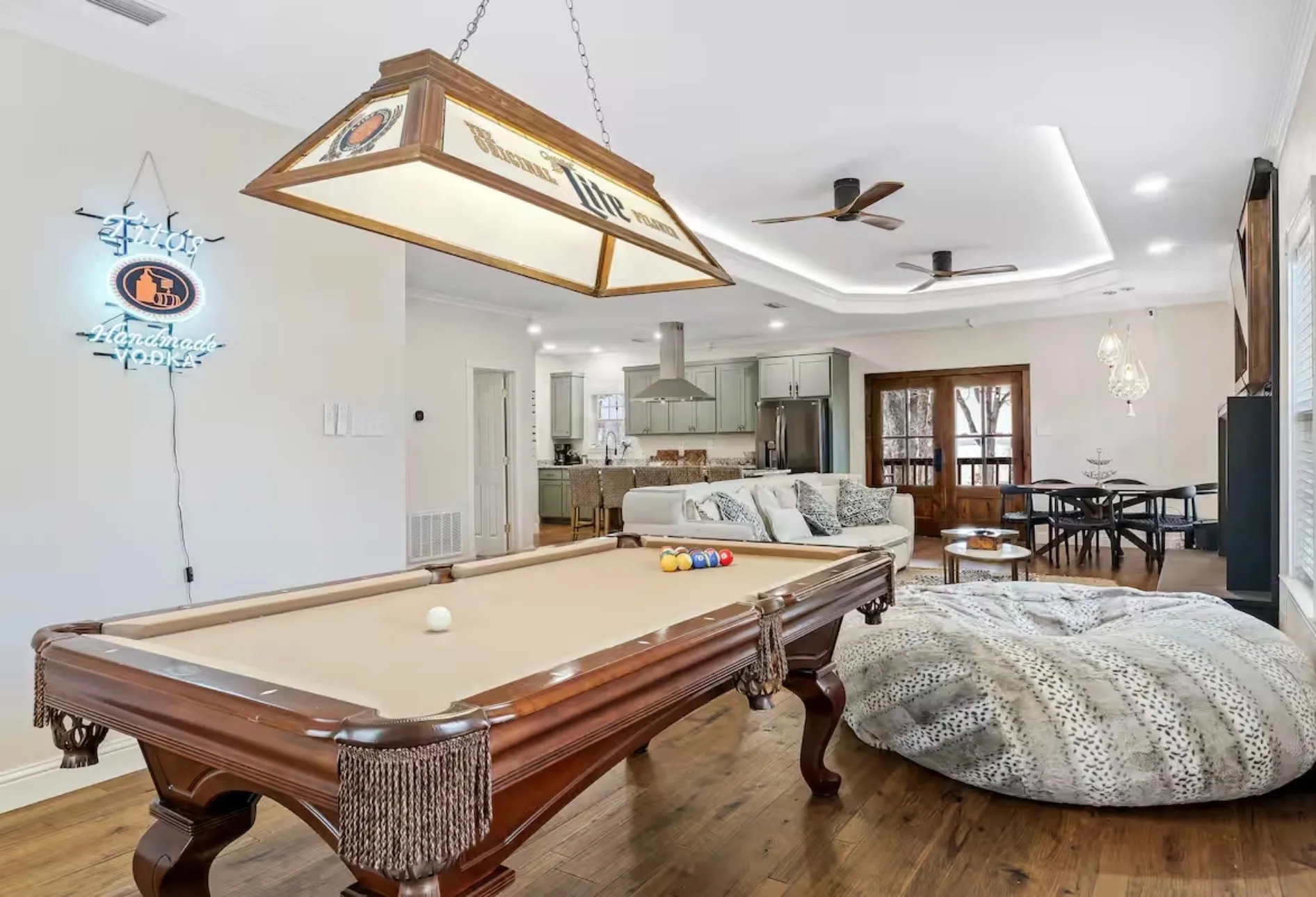 Open-concept entertainment space featuring a billiards area with a classic pool table, recessed ceiling lighting, and wood-finish flooring