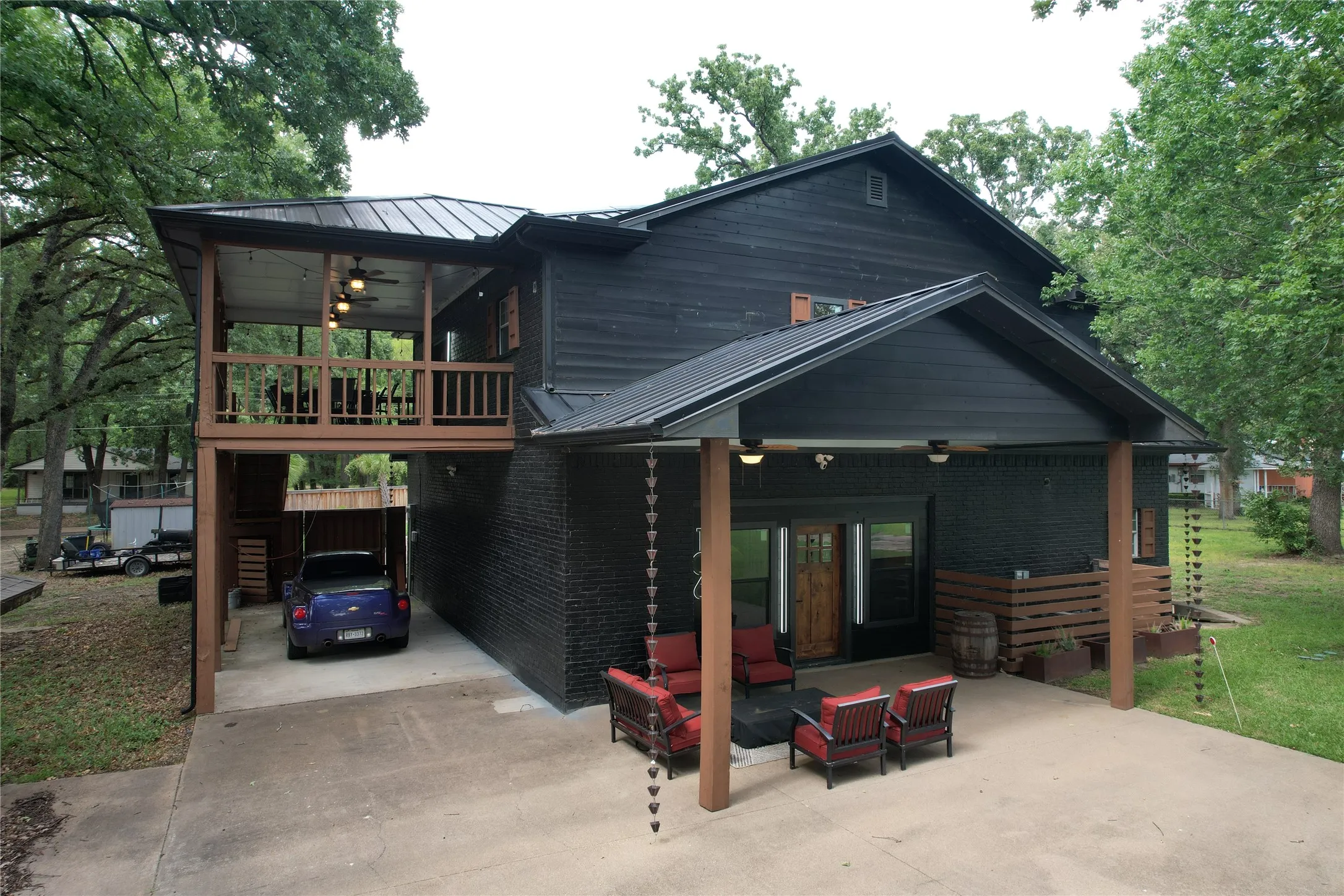 Lakeview side of structure showing the. covered upstairs main living entry covered deck and the covered carpot patio and covered Barndo garage downstairs porch entry.  Wood Gate under covered deck provides access to the large enclosed private backyard on the White Oak Dr frontage of house.  A very versatile property.