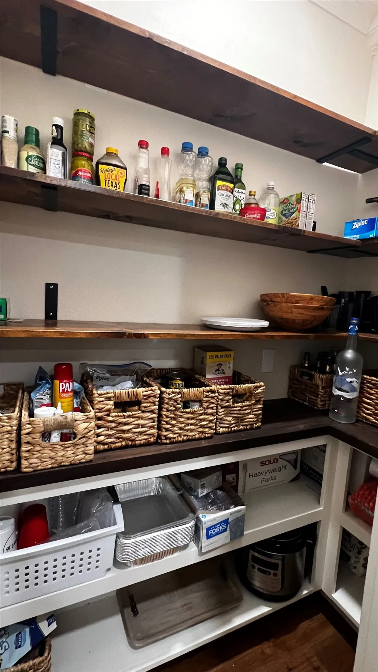 Walk-in Pantry with built-in pantry shelving featuring dark wood-finish open shelving, white cabinetry, and a corner configuration for maximized storage
